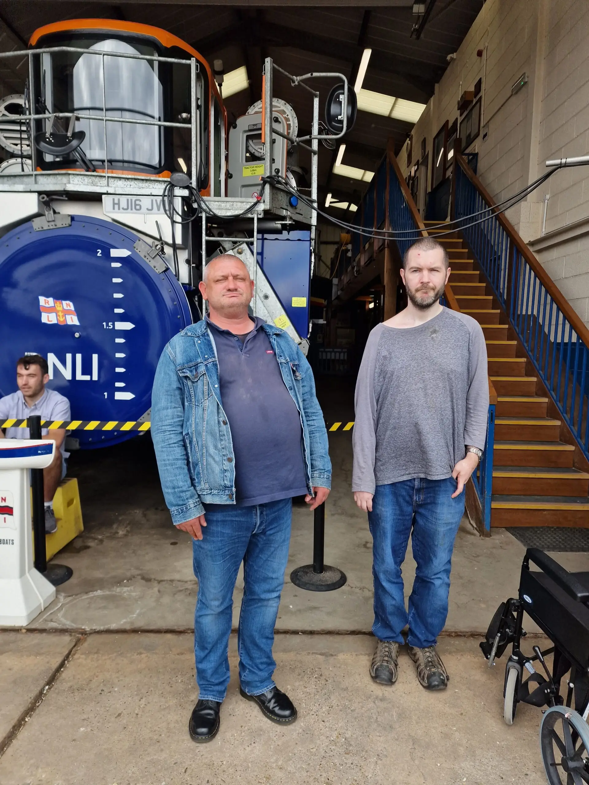 two male residents outside of lifeboat shed