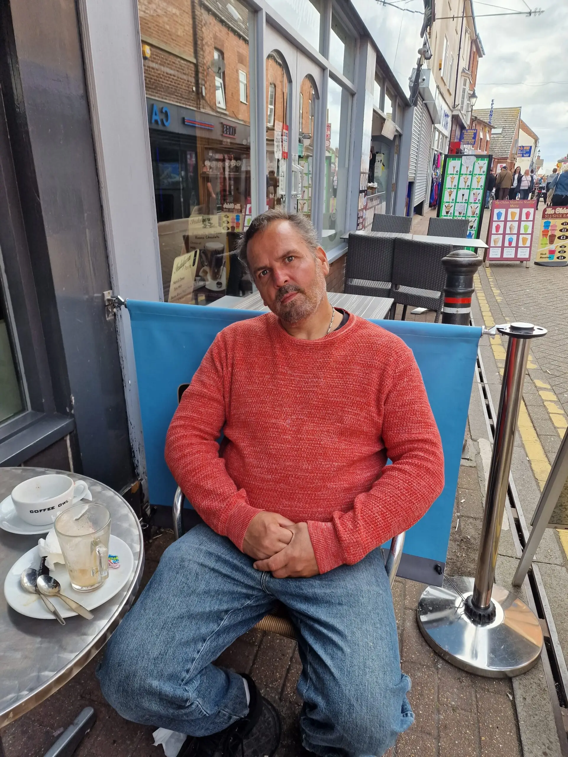 resident in red jumper sitting outside coffee shop