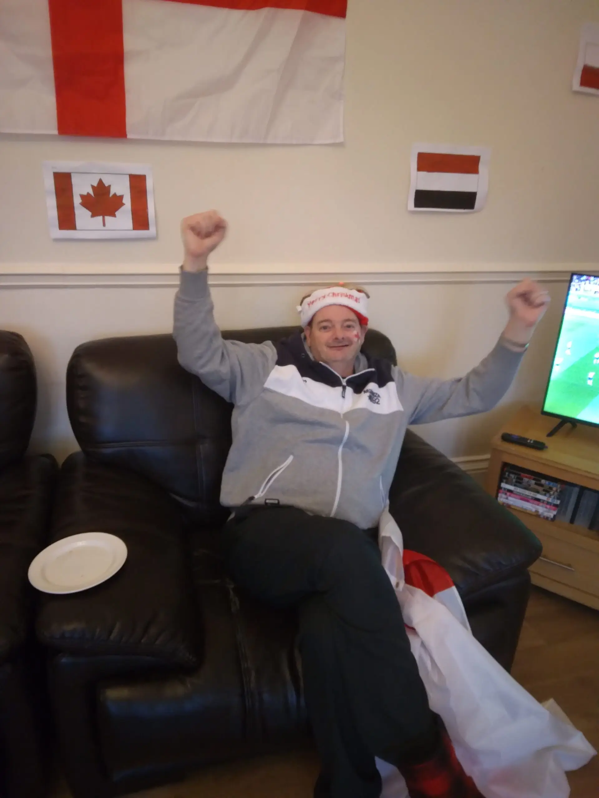 Resident cheering on England while wearing red and white hat