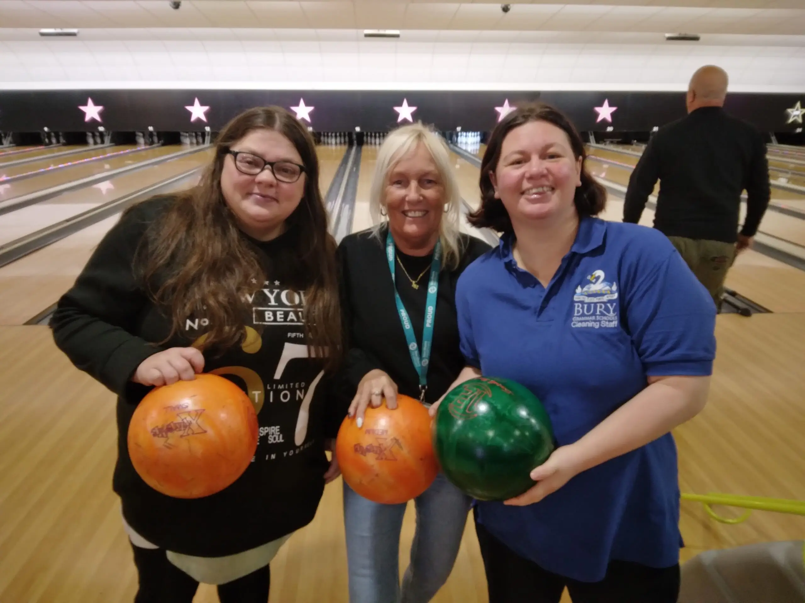 residents and team member holding bowling balls posing together