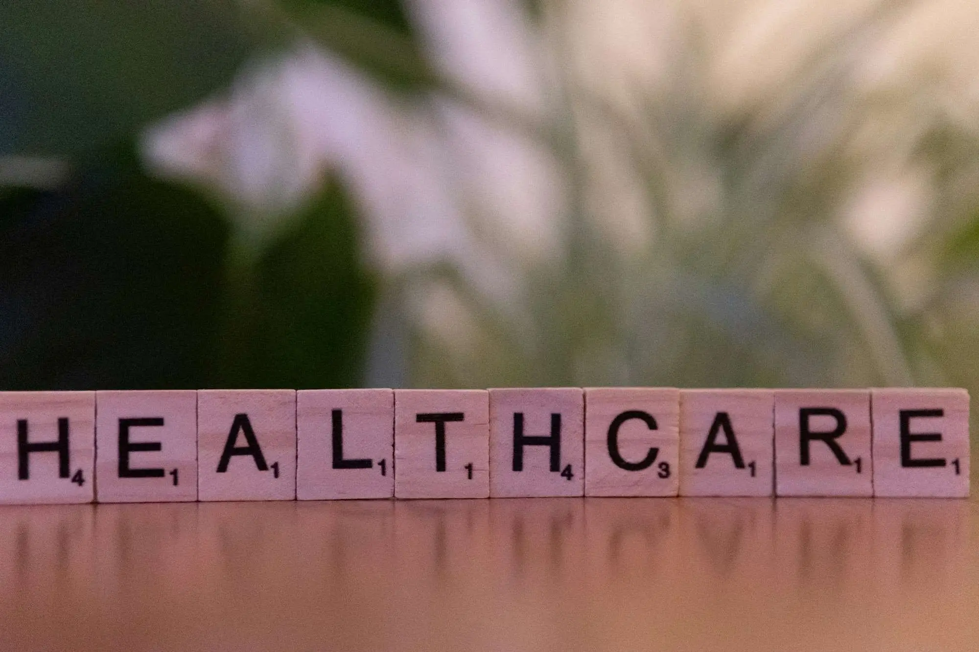 Scrabble tiles spelling HEALTHCARE on a table