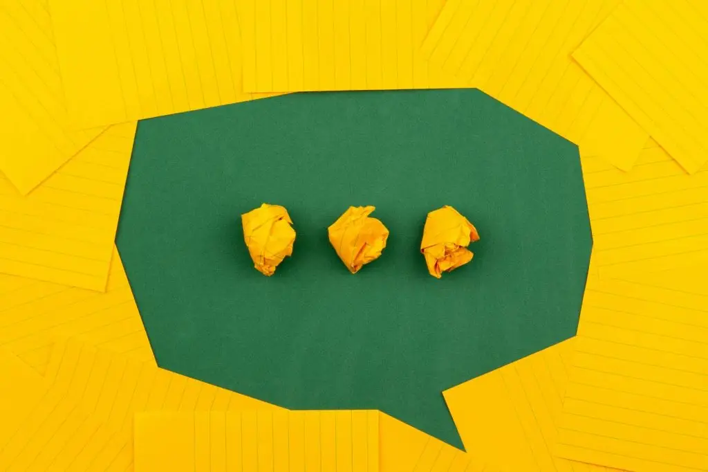 Speech bubble made of green and yellow paper for a blog on talking about mental health in supported living.