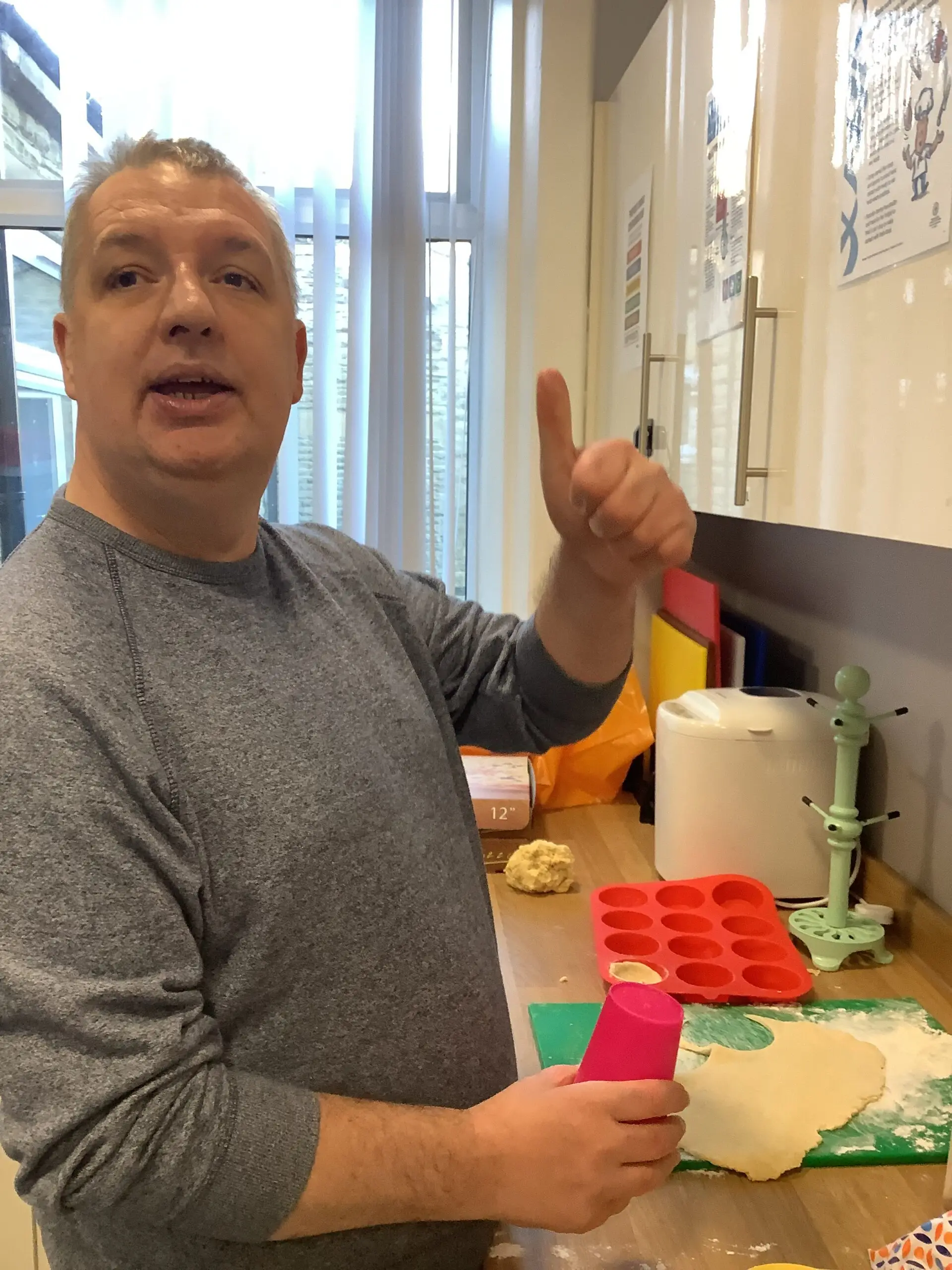 resident in kitchen with thumbs up to camera