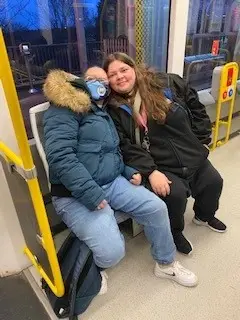 residents on the bus wearing Man City hats and scarves