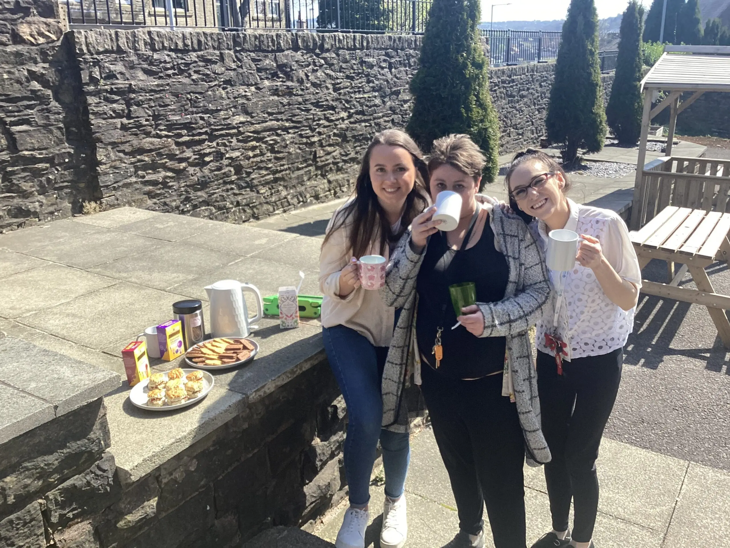 team members enjoying tea and biscuits outdoors