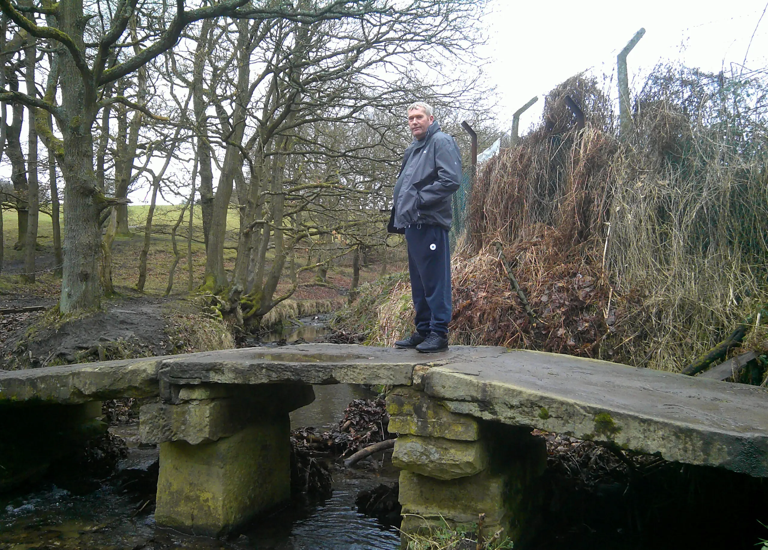 resident on stone bridge over stream