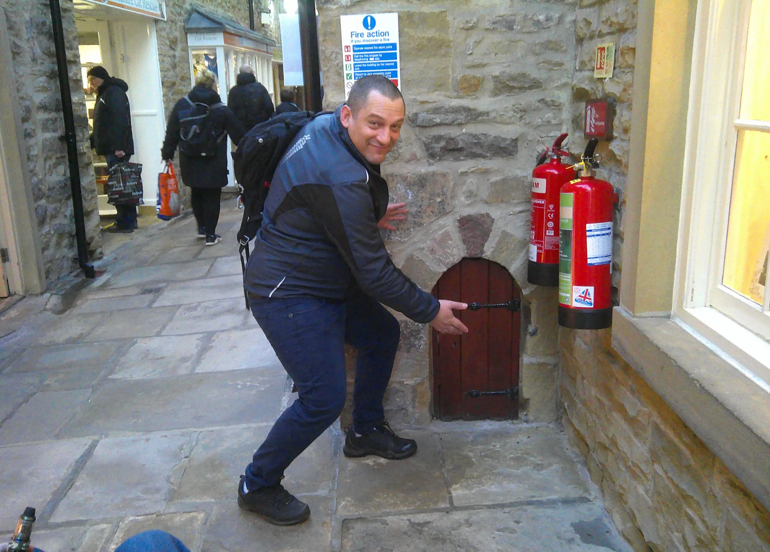 resident pointing to a small wooden door in the wall