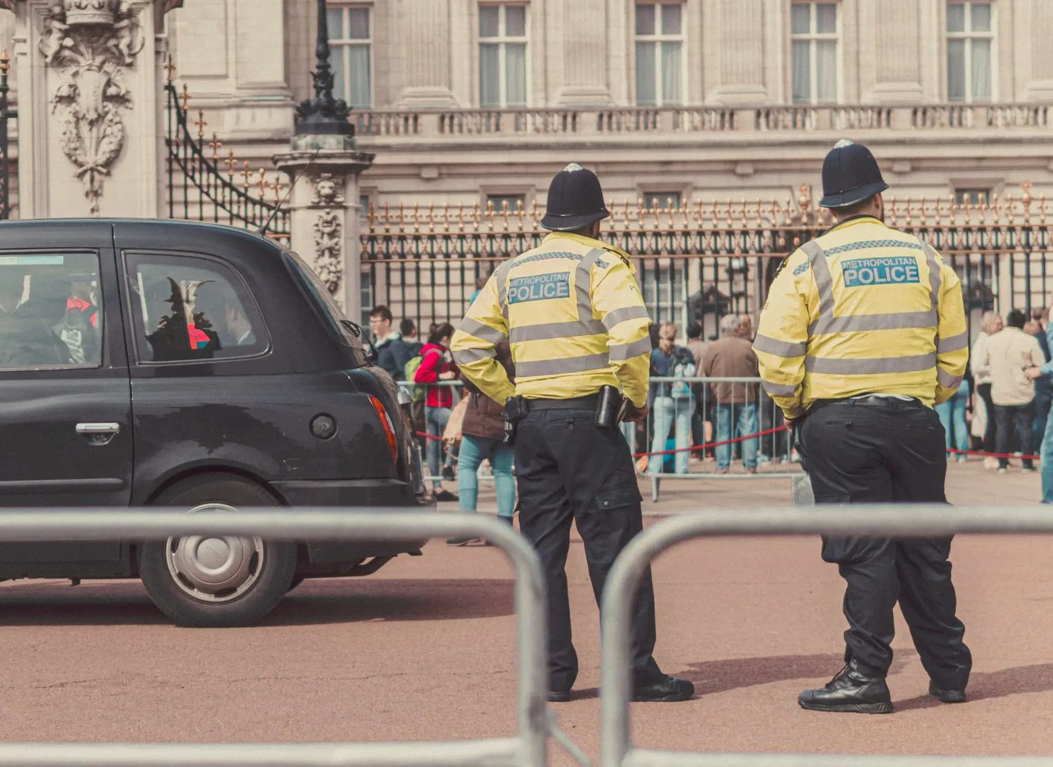 two policemen in yellow police jackets with backs to camera