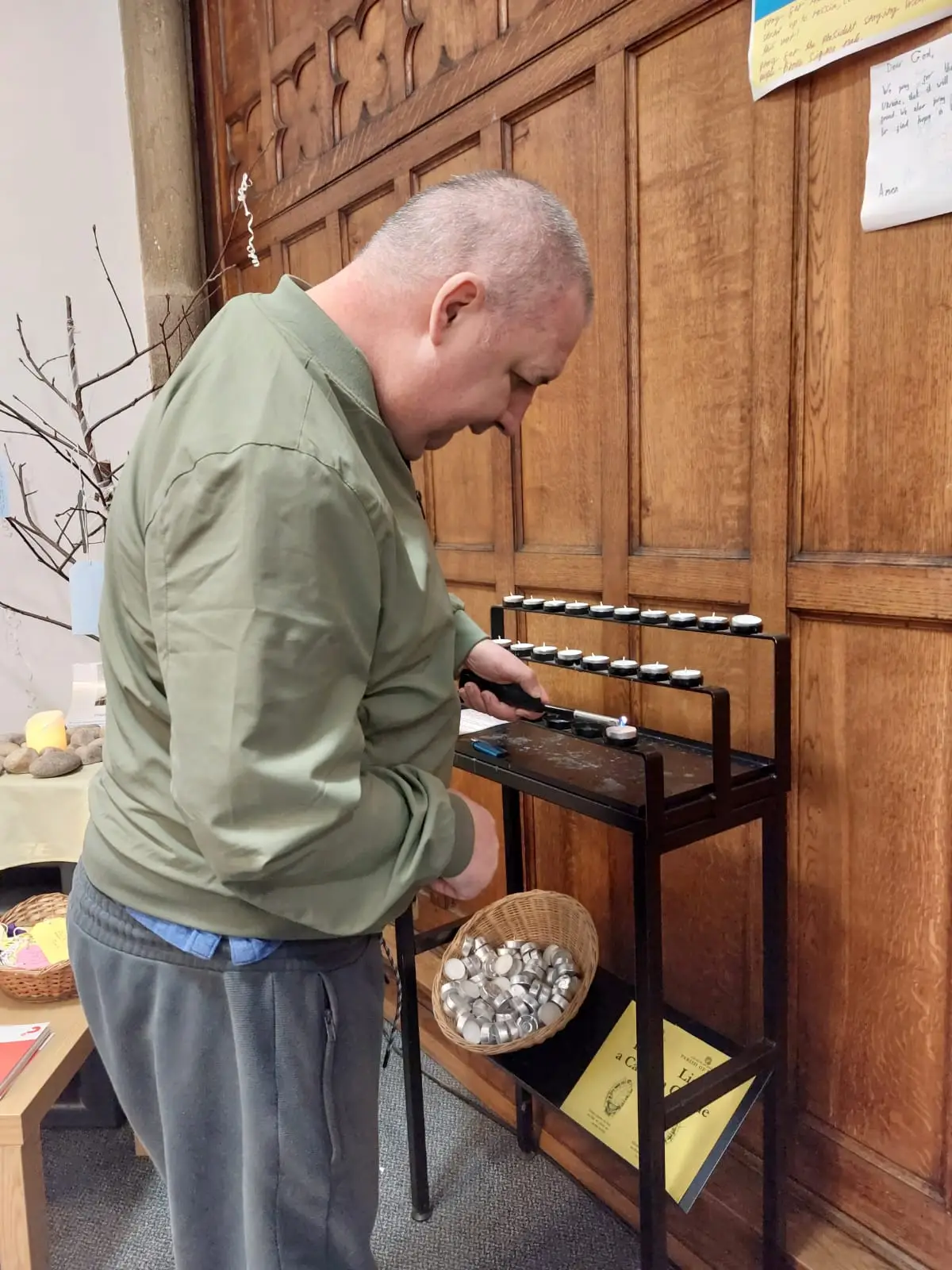 resident lighting a candle in church