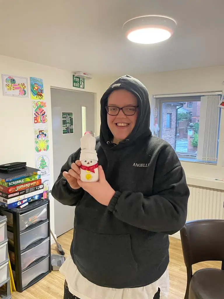 resident holding snowman decoration
