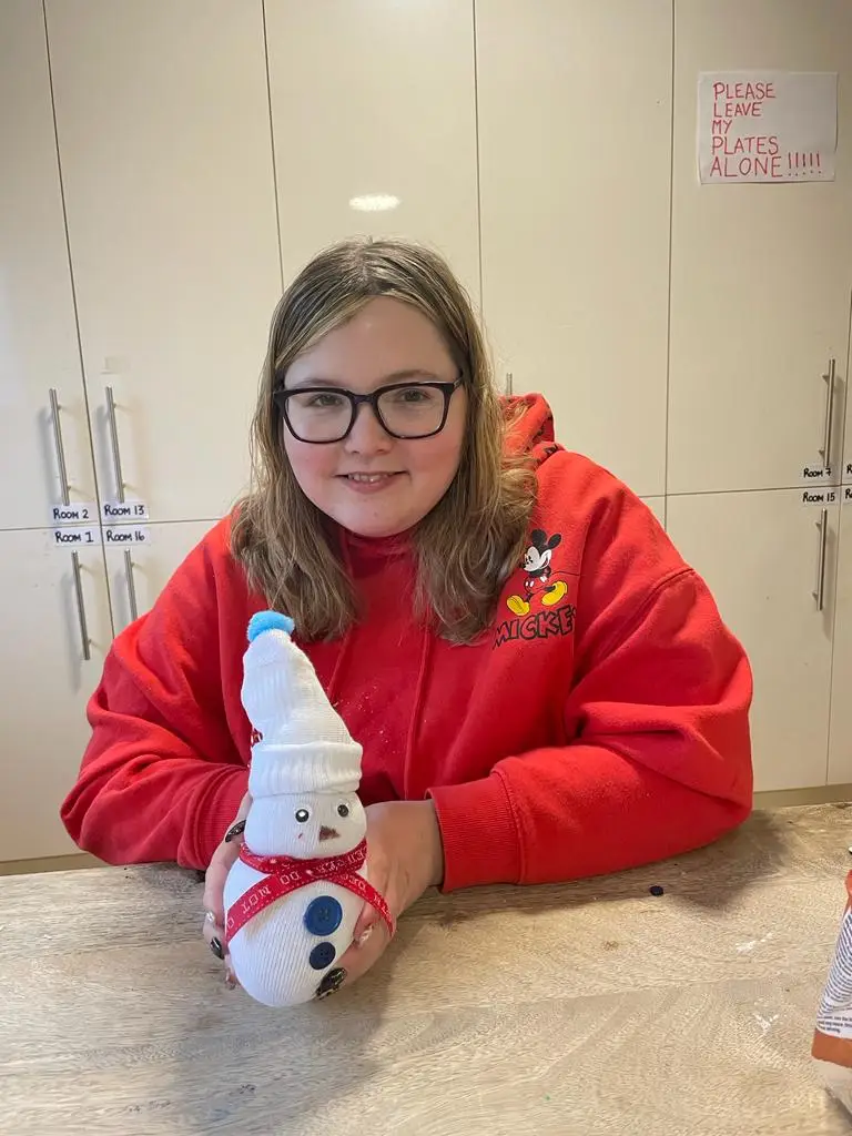 resident holding snowman decoration