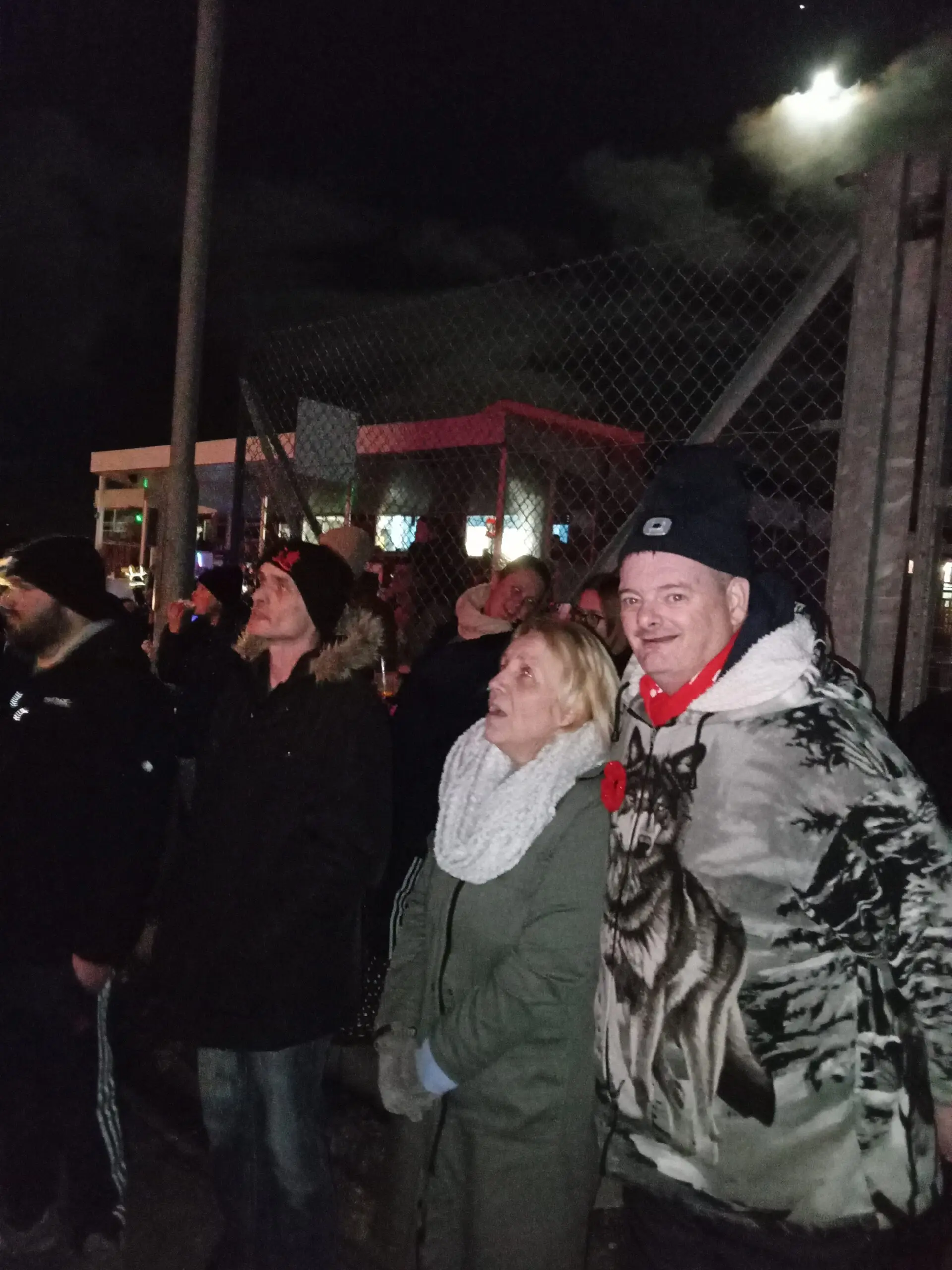 residents outdoors wrapped up warm watching fireworks