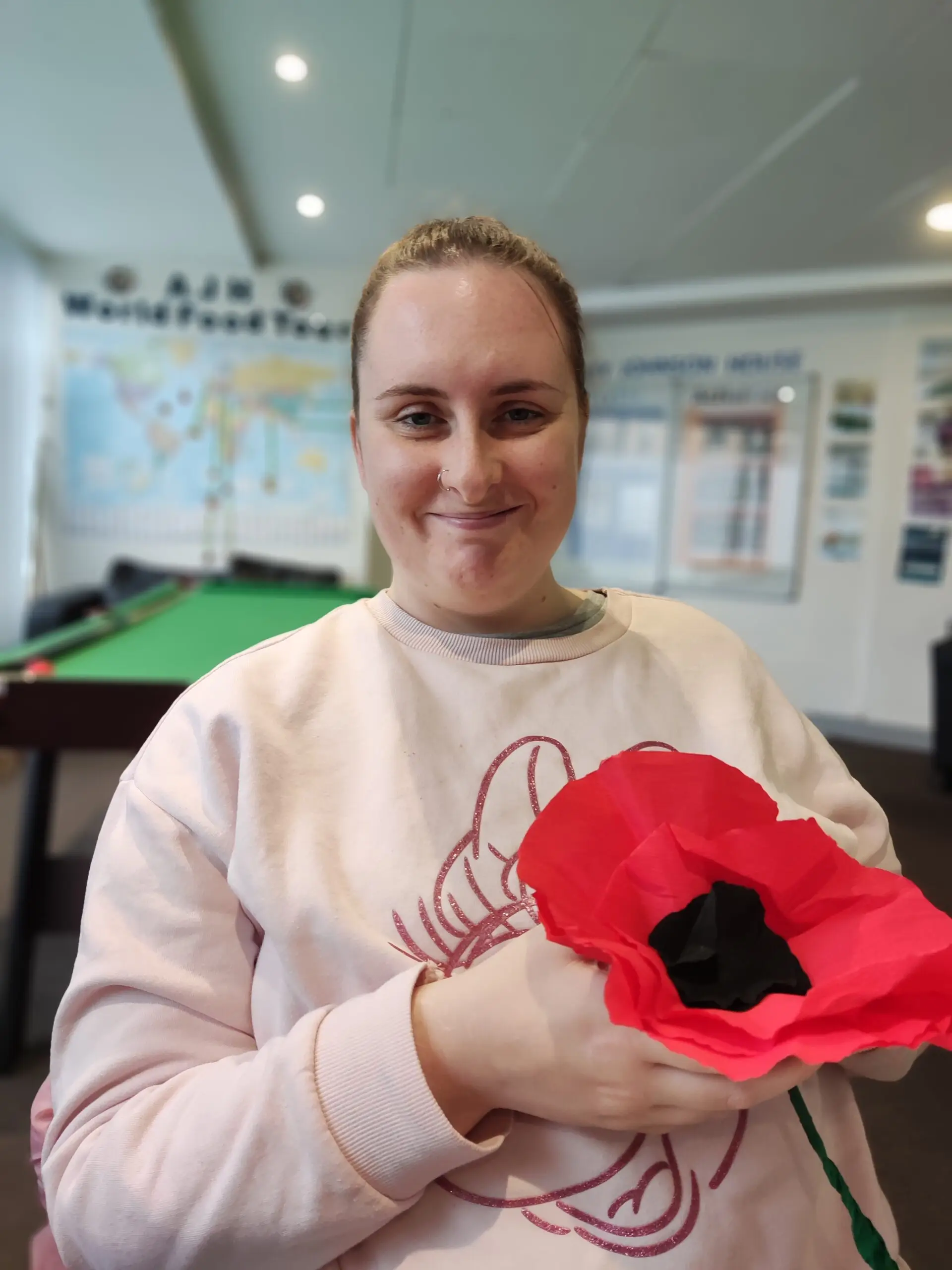 resident holding giant paper poppy