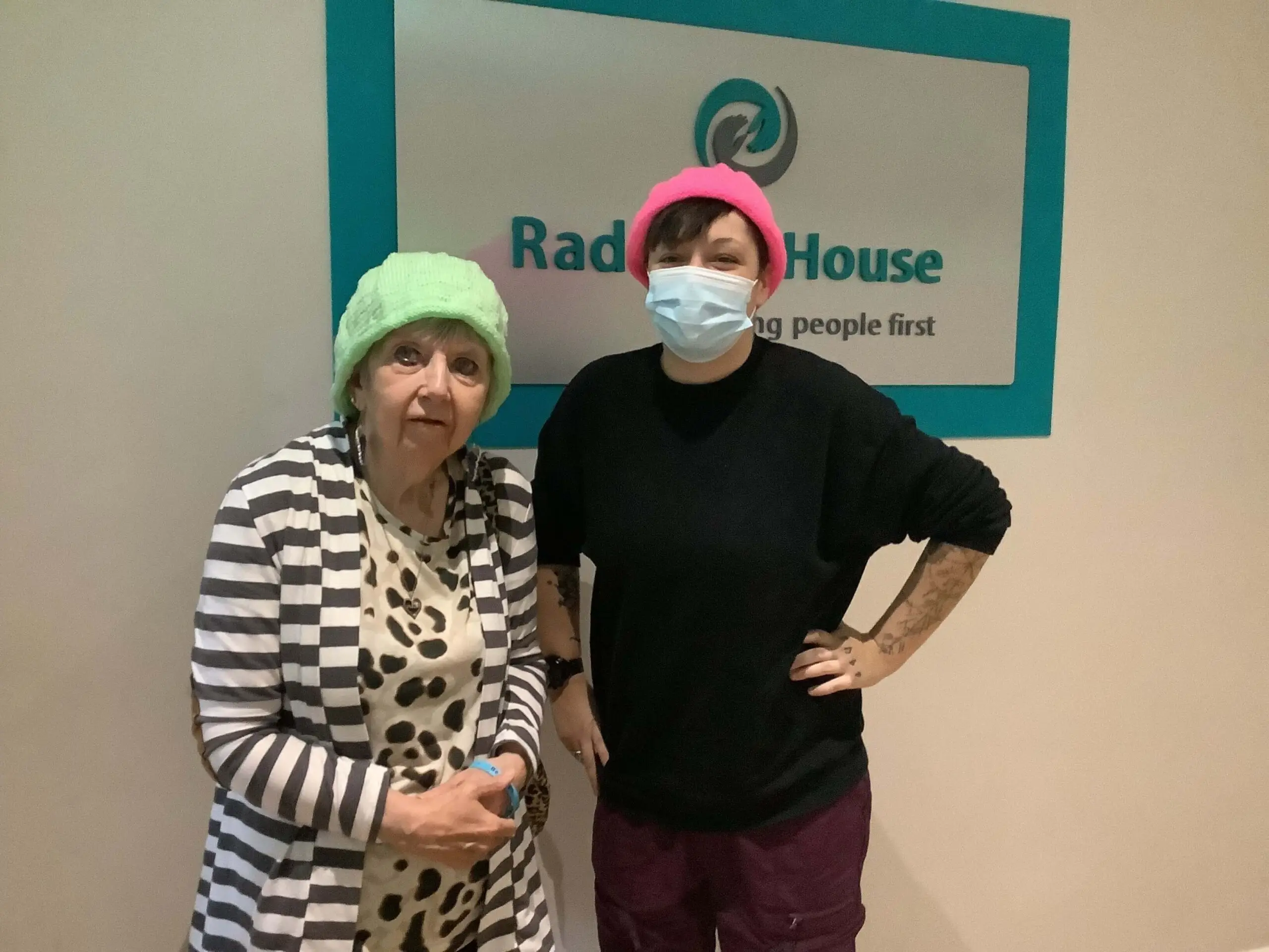 resident and team member wearing knitted hats