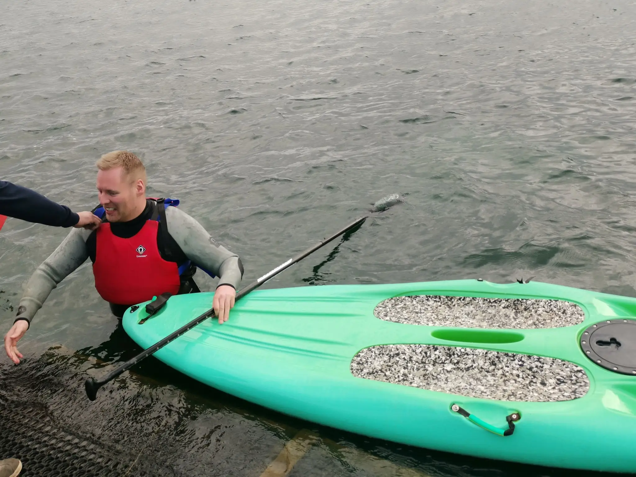 Man in water holding paddle board