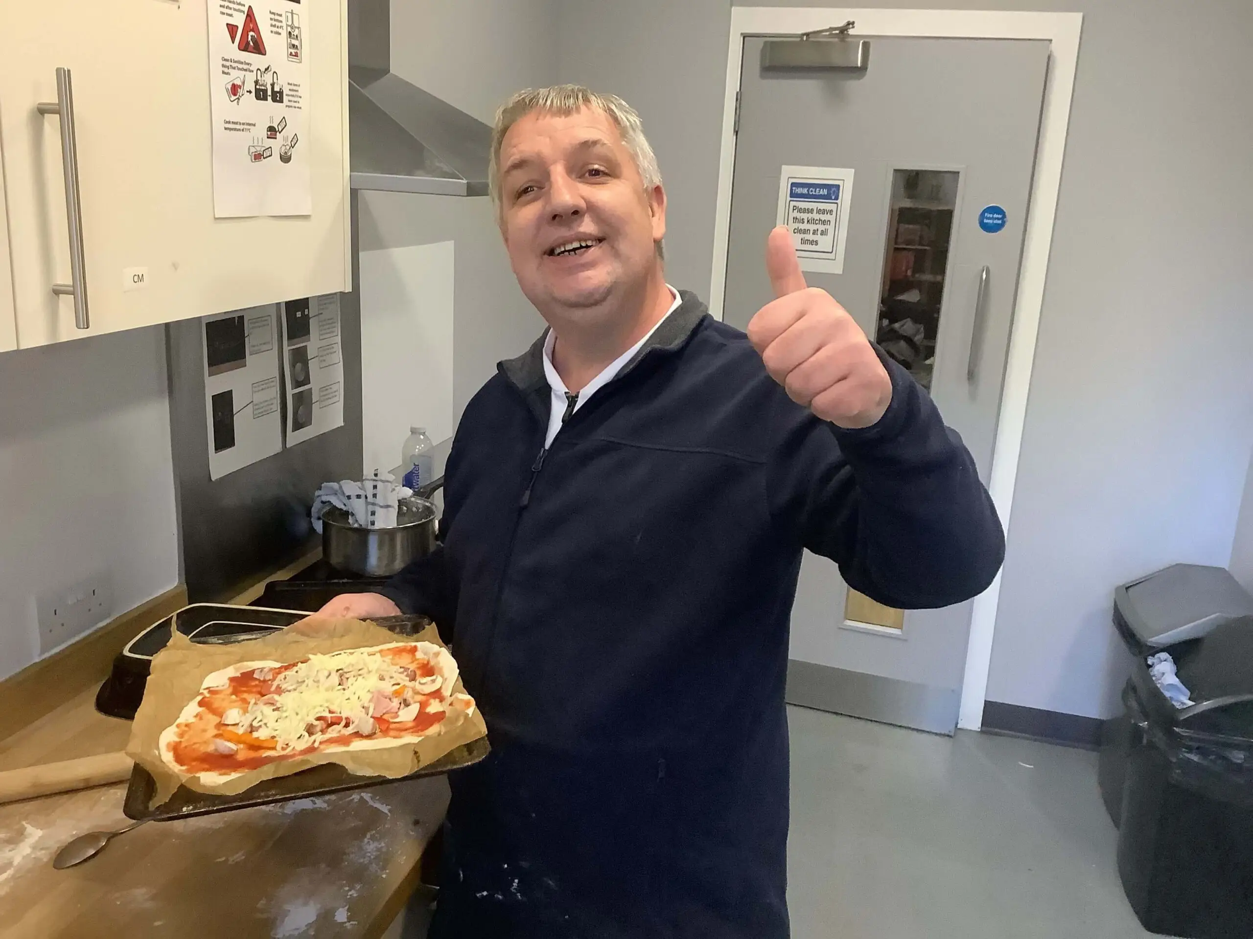 resident with thumbs up and mozzarella pizza