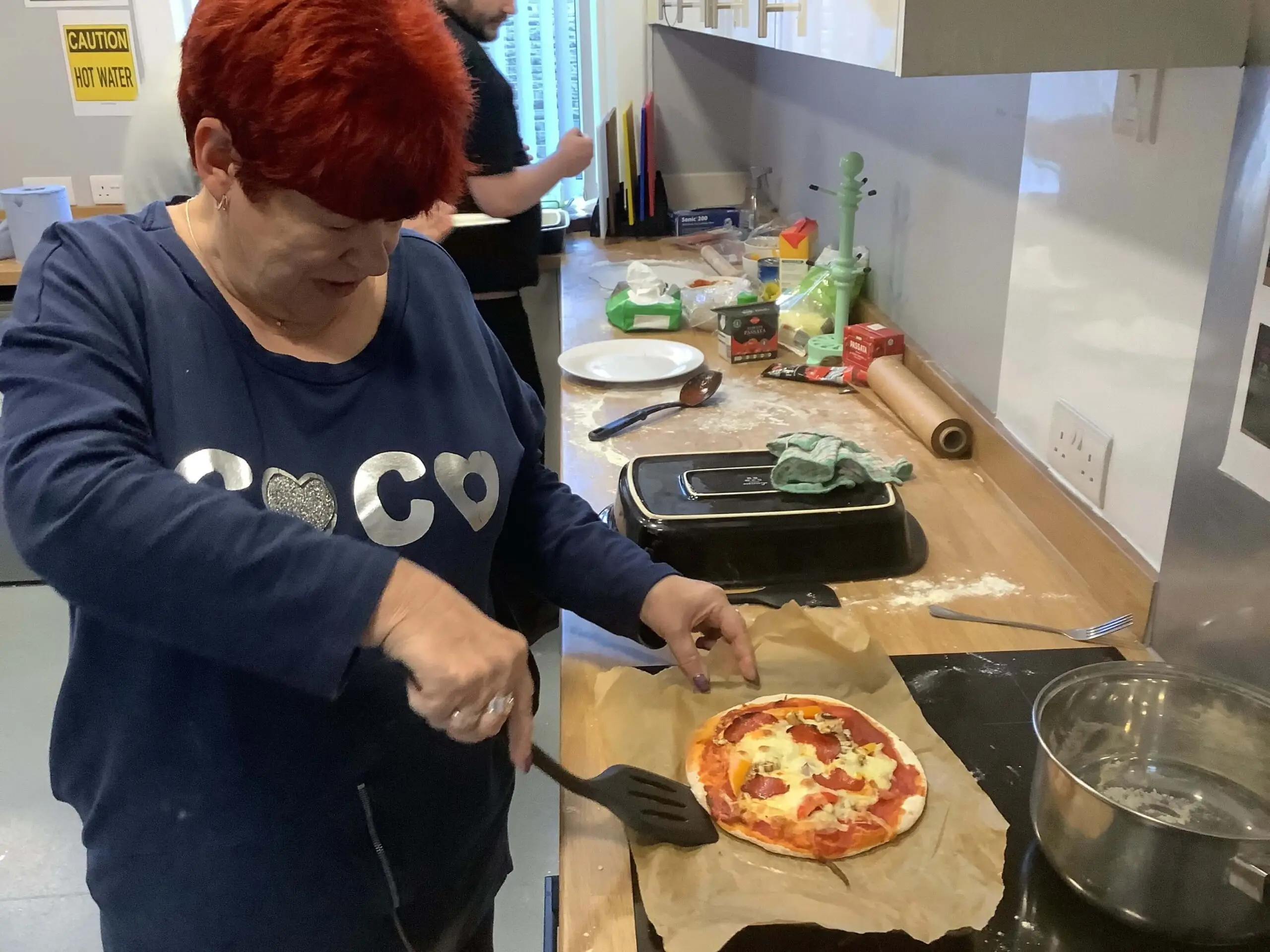 resident taking pizza off over tray