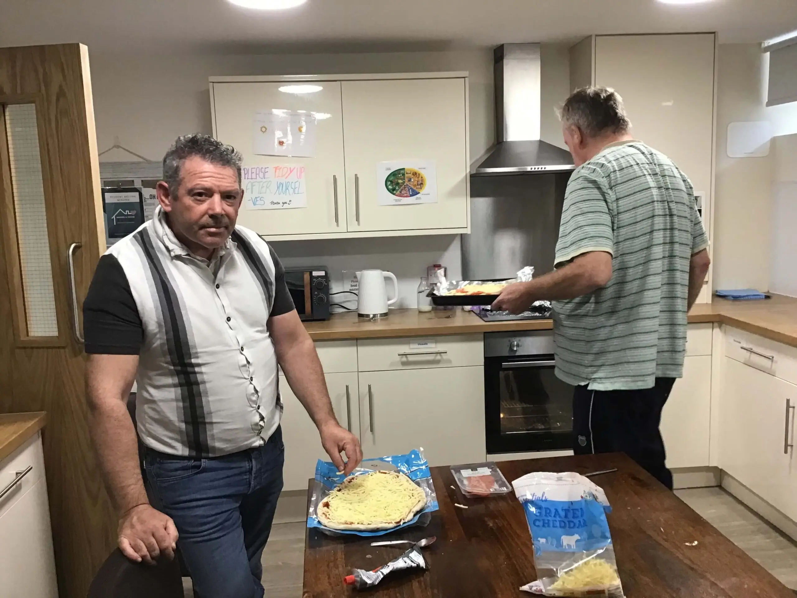 Resident putting pizza in the oven