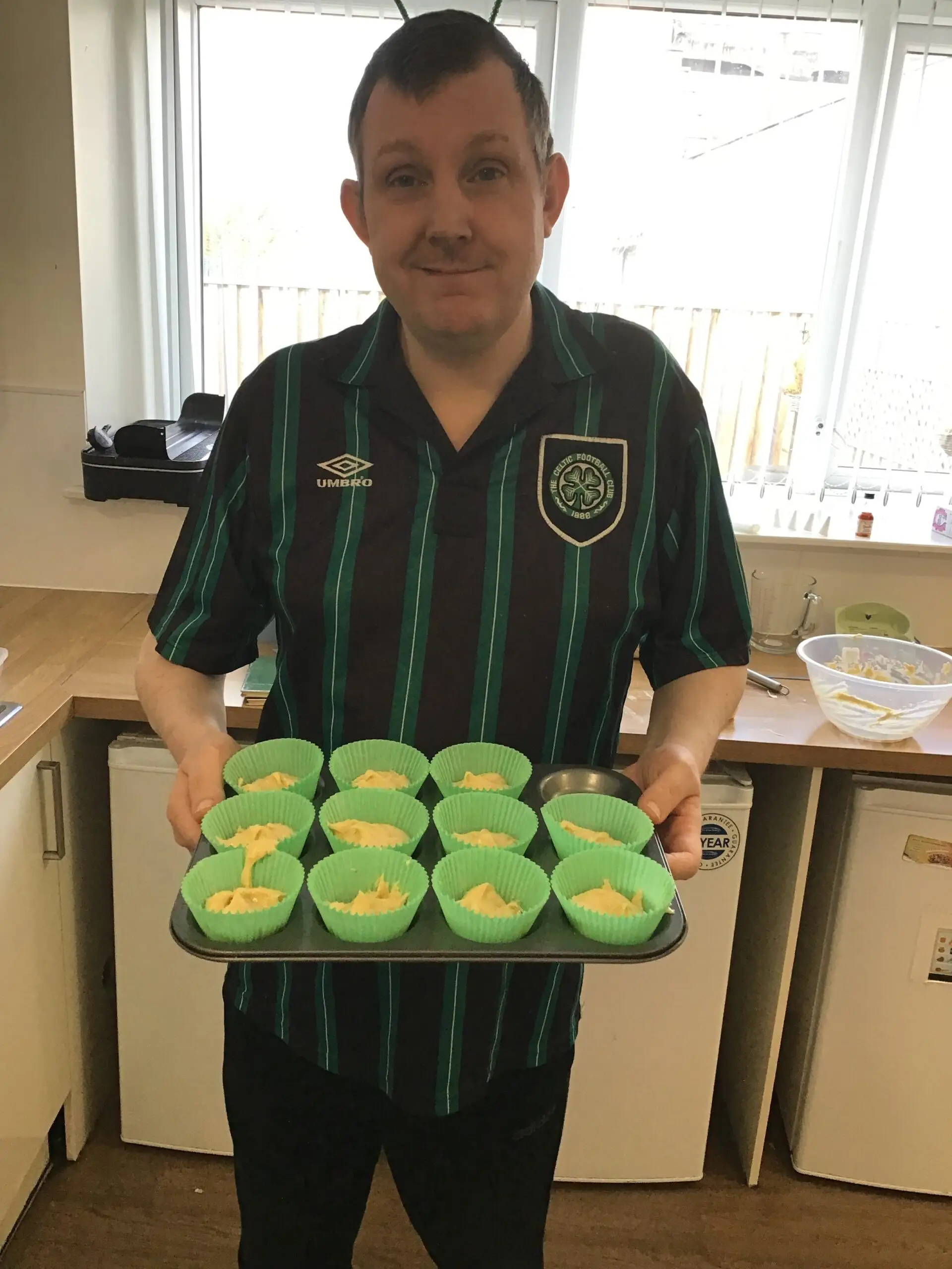 resident holding tray of cupcakes ready for the oven