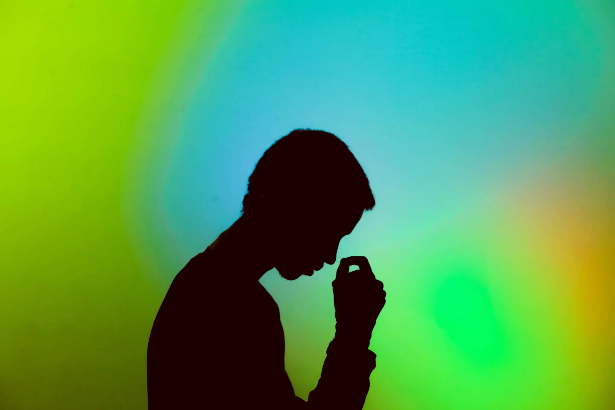 Man with neon background with head in hands