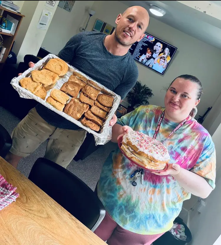 residents holding finished biscuits and cake