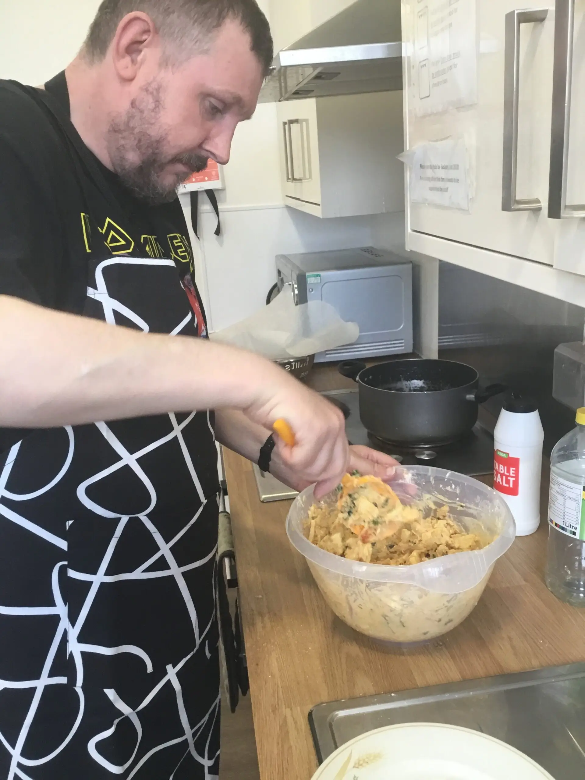 resident mixing onion bhaji mixture in bowl