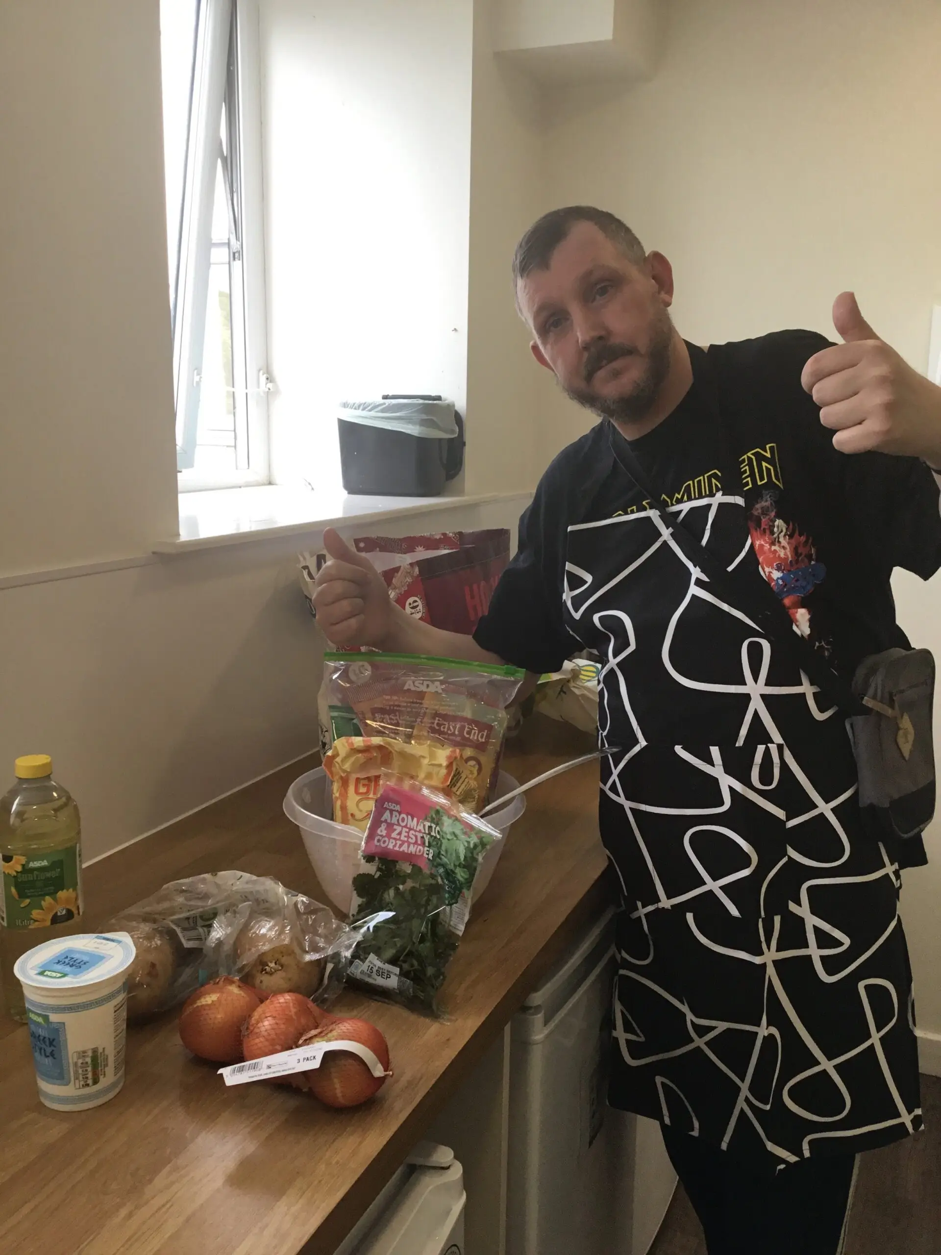 resident with thumbs up next to pile of ingredients