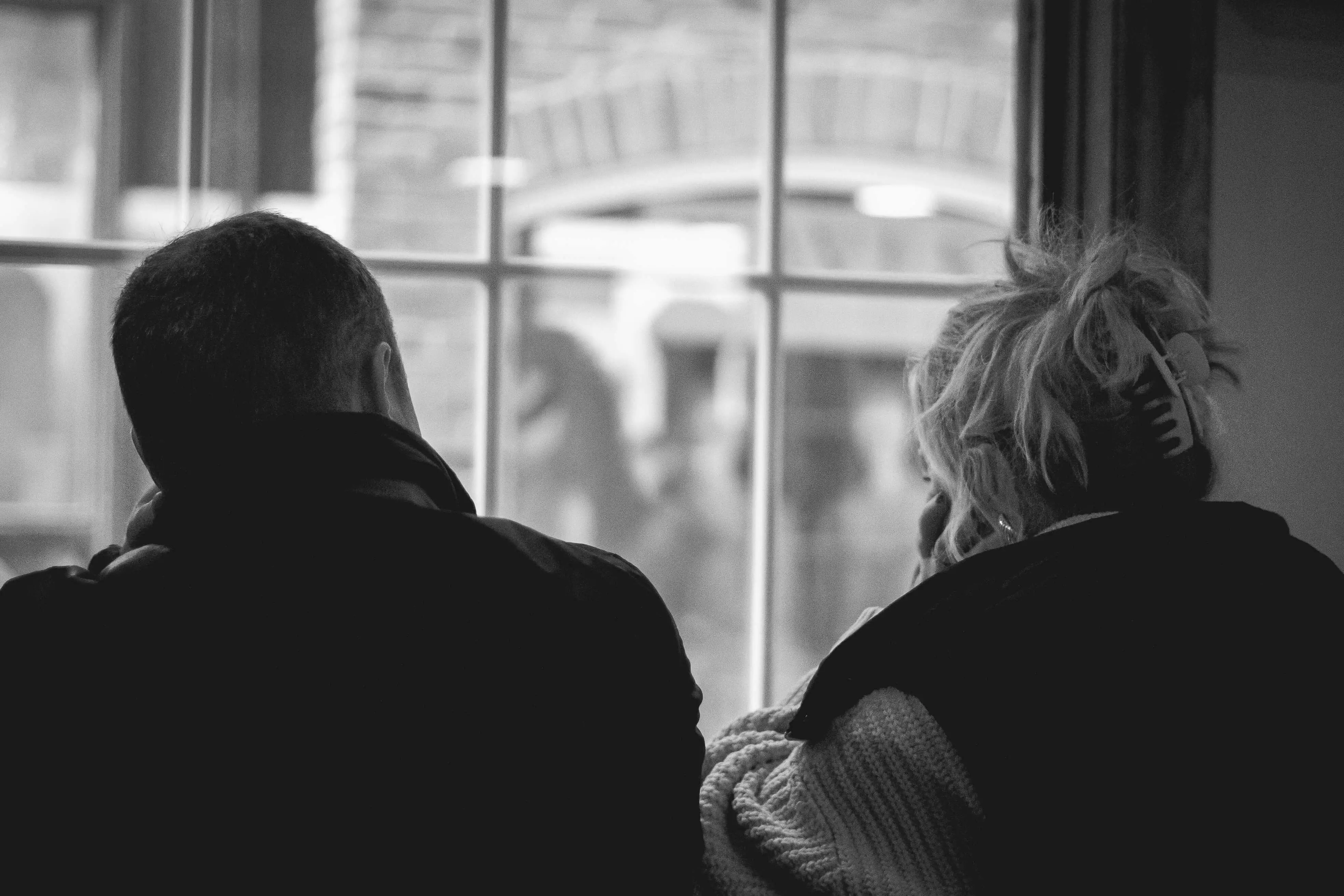 Two people facing a window comforting each other for a blog about planning for a mental health crisis.