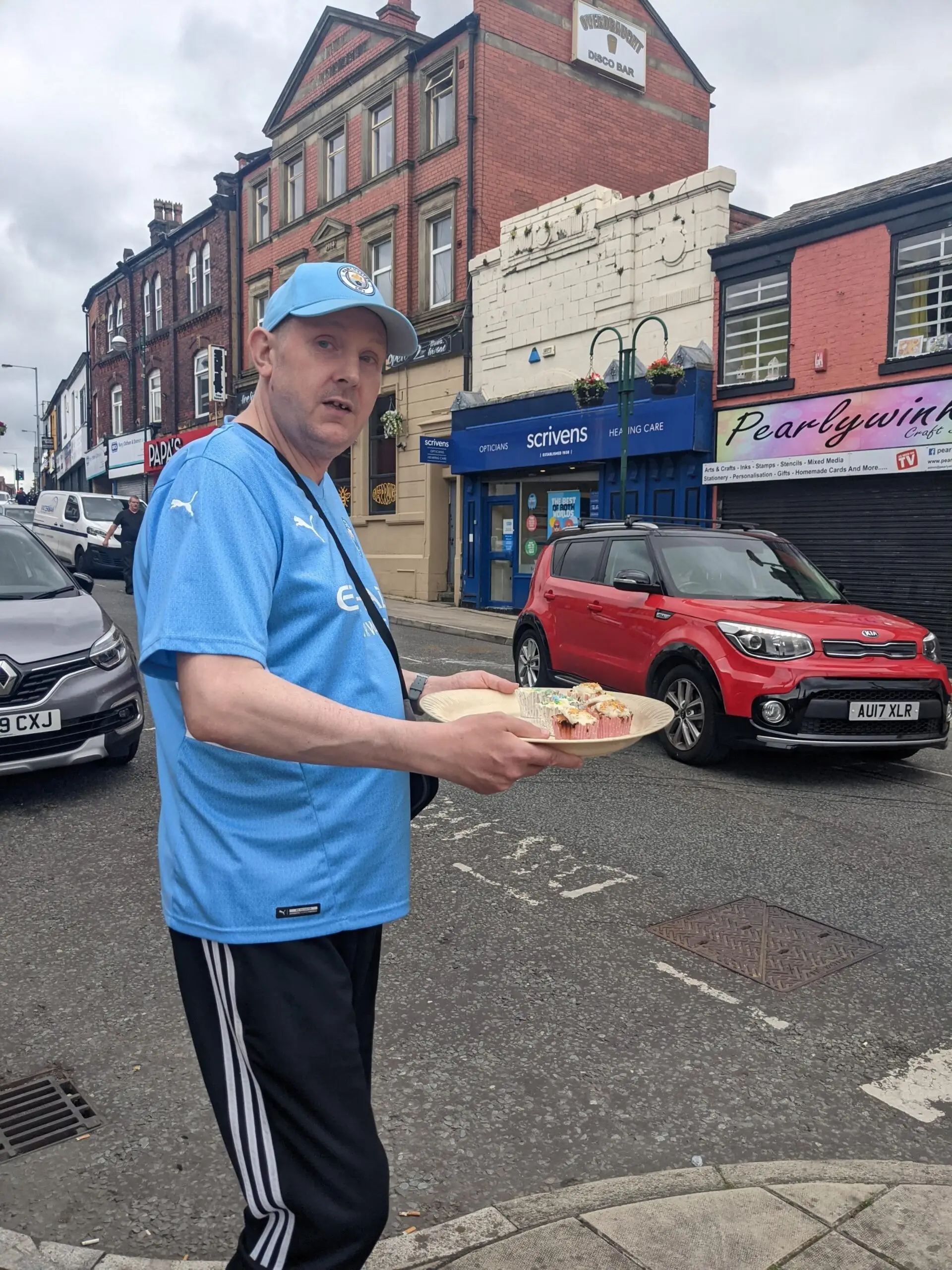 resident holding tray of cupcakes