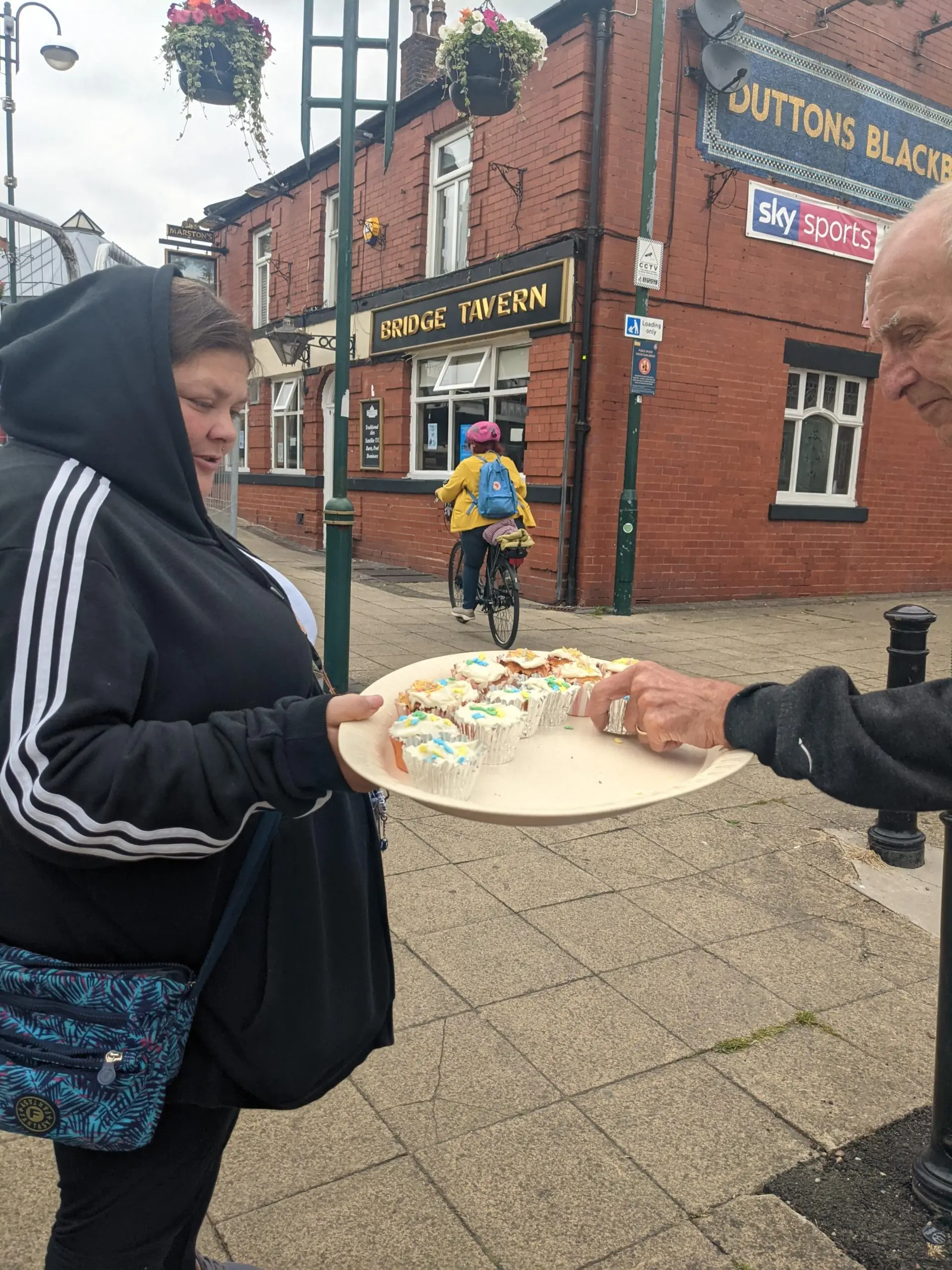 resident handing out cupcakes to the local public