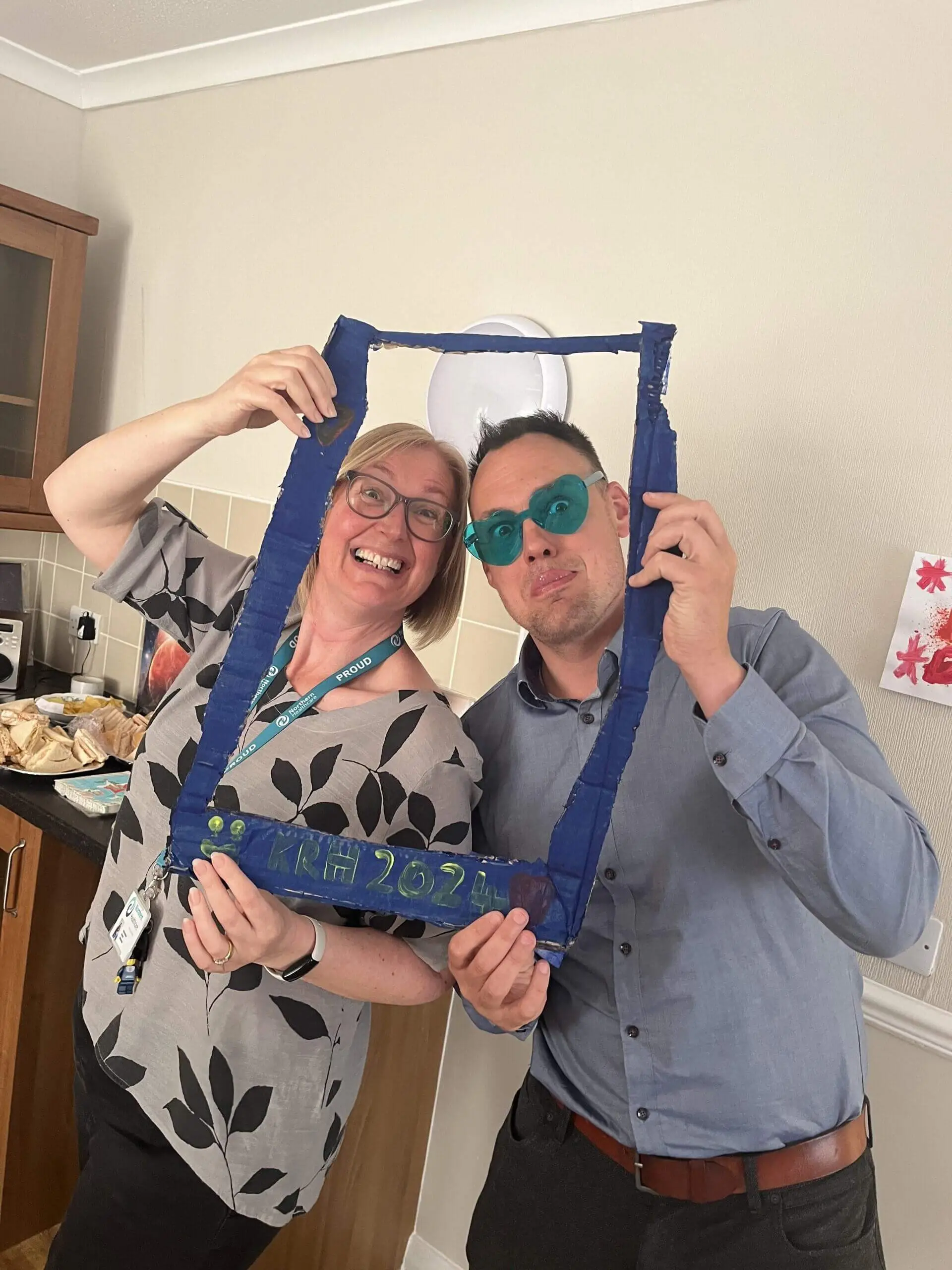Lady and gentleman posing with frame