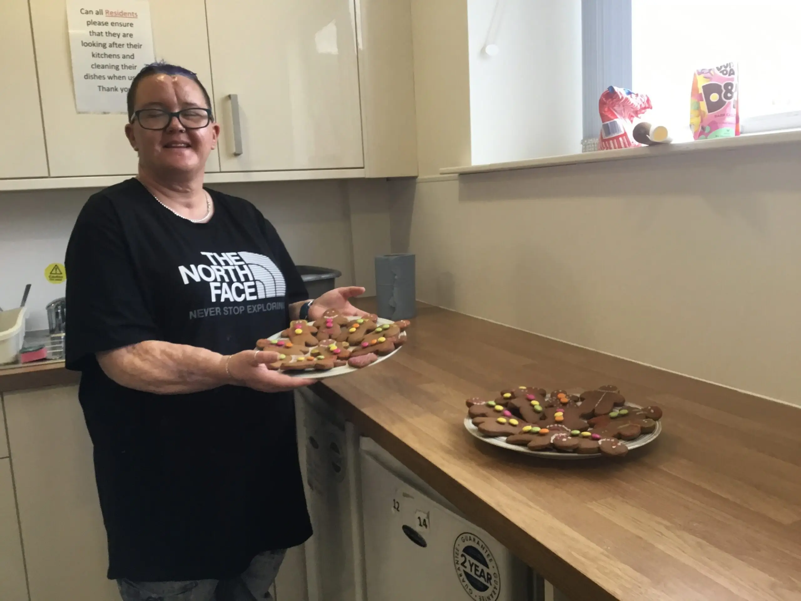 resident holding plate of homemade vegan gingerbread biscuits