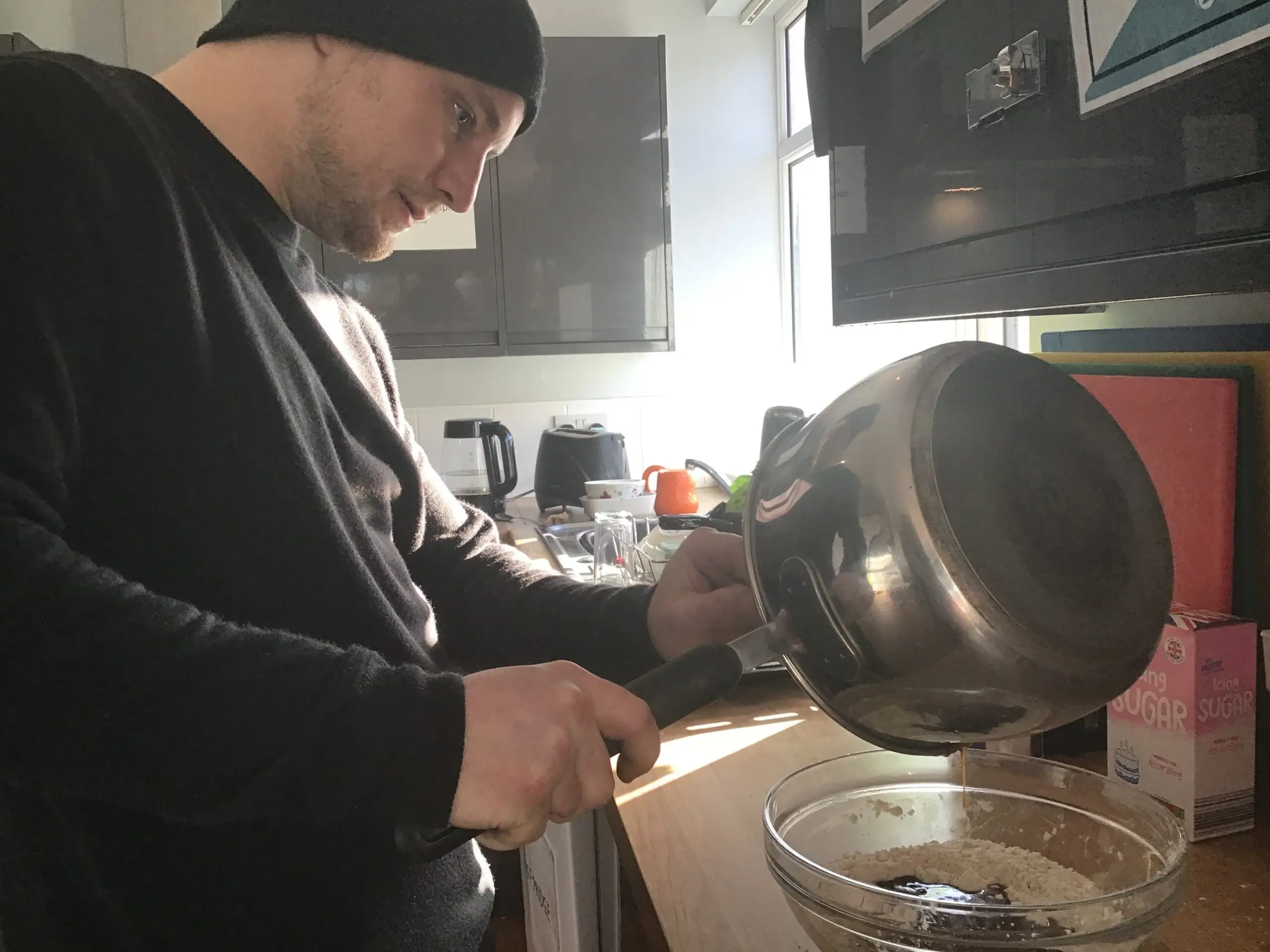 resident pouring biscuit batter into bowl