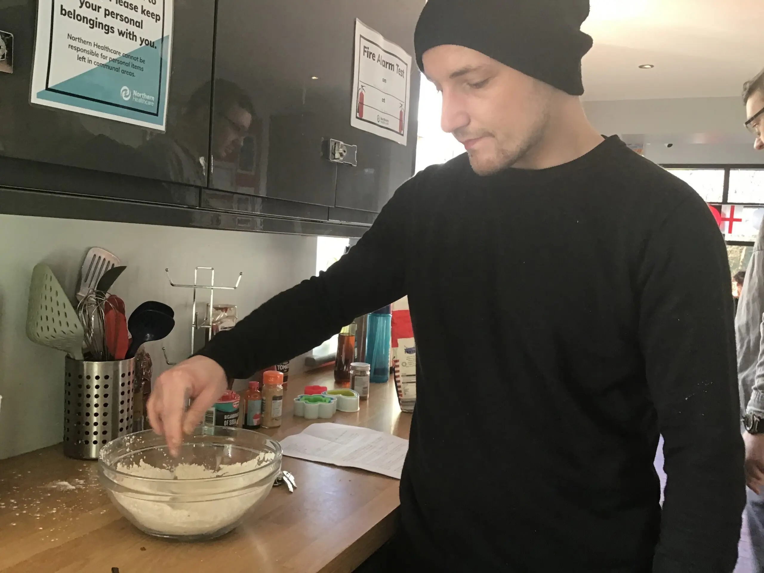 resident adding ingredients to mixing bowl