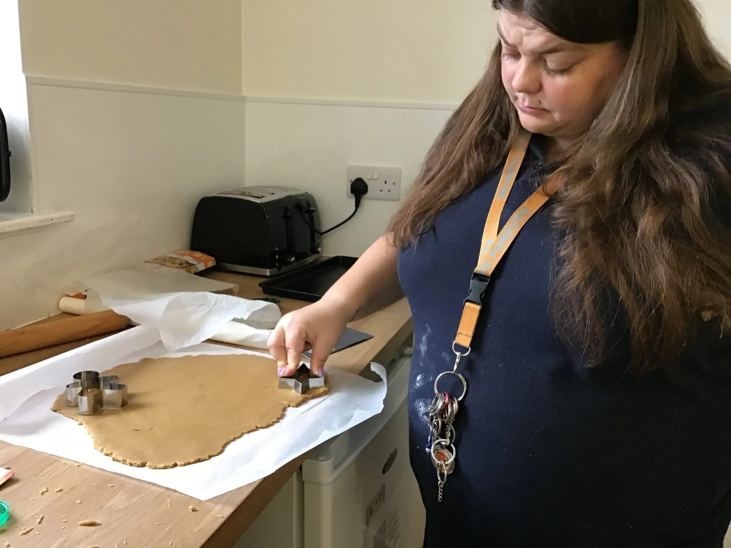 resident using cookie cutter to cut out gingerbread cookies