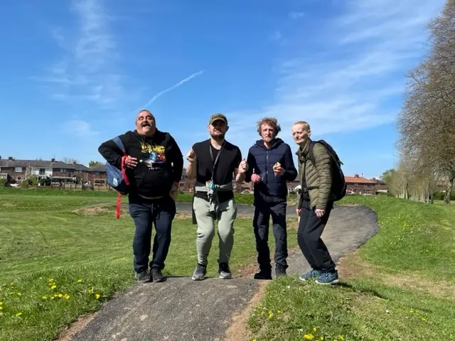4 residents on field with blue sky