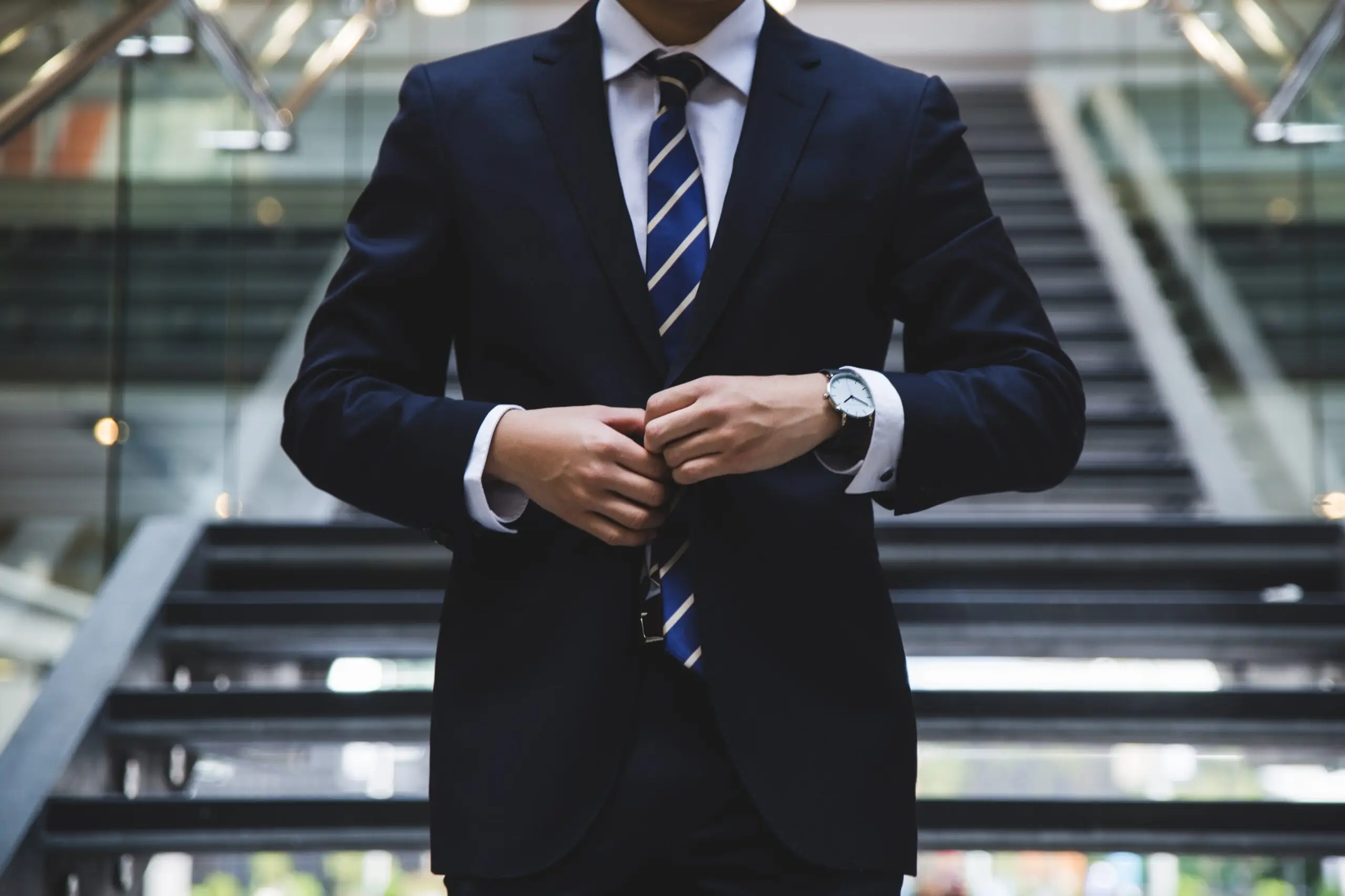 man in suit buttoning up his jacket