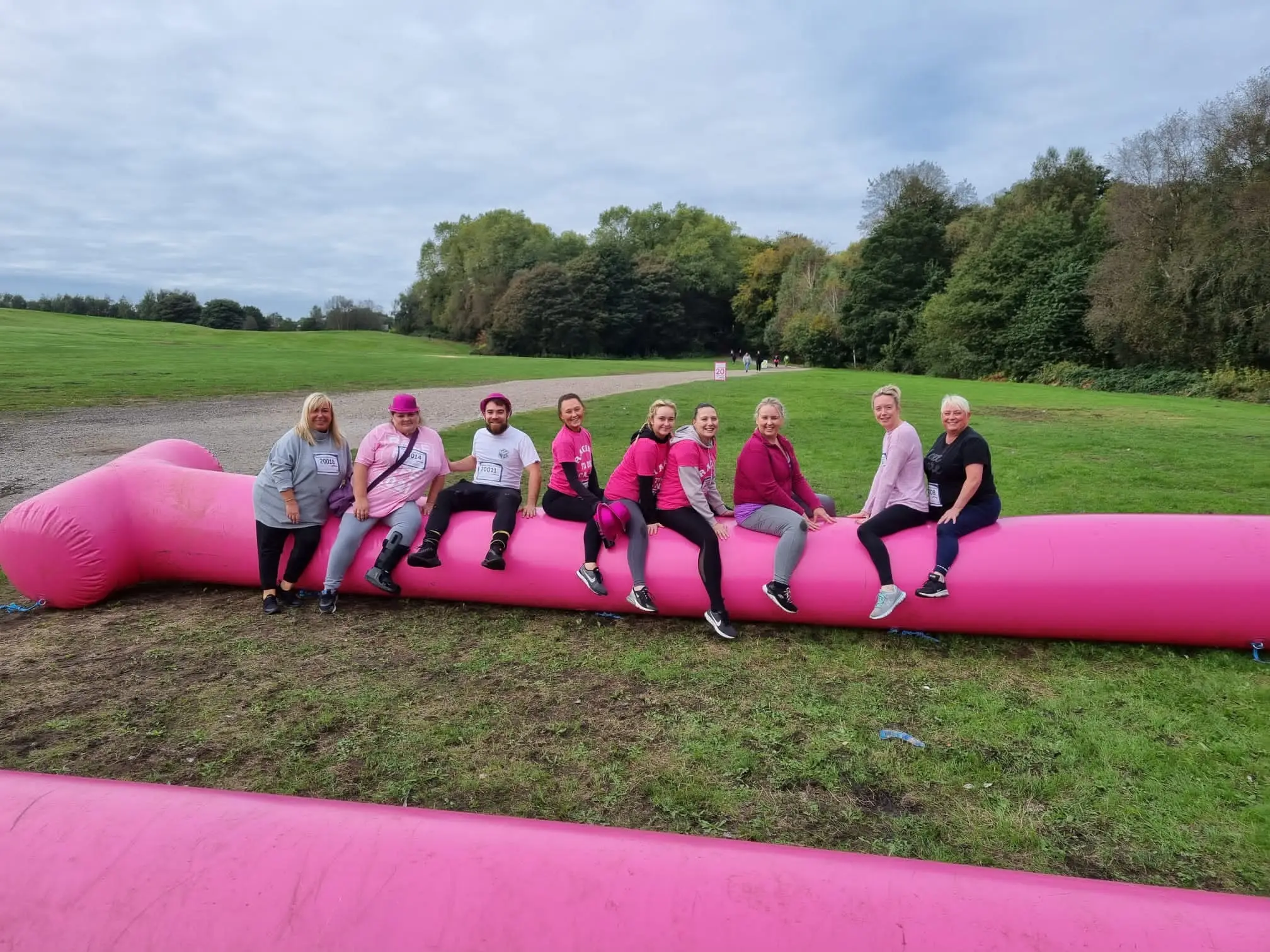 the team climbing over an inflatable pink tube