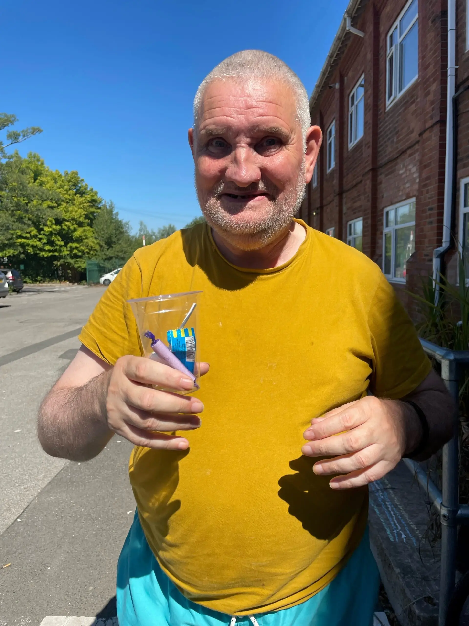resident wearing yellow tshirt holding plastic cup of sweets