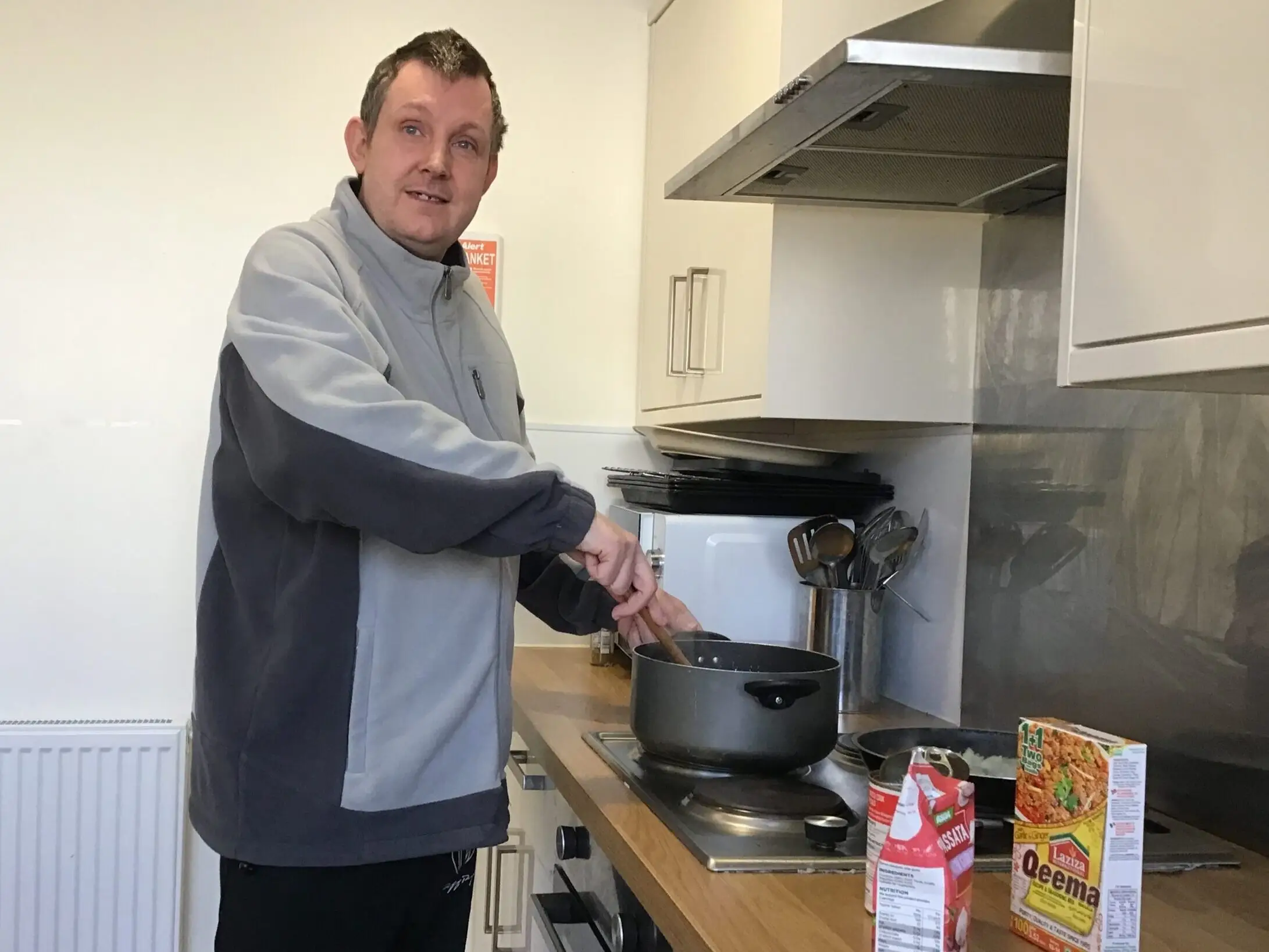 resident stirring curry in pan