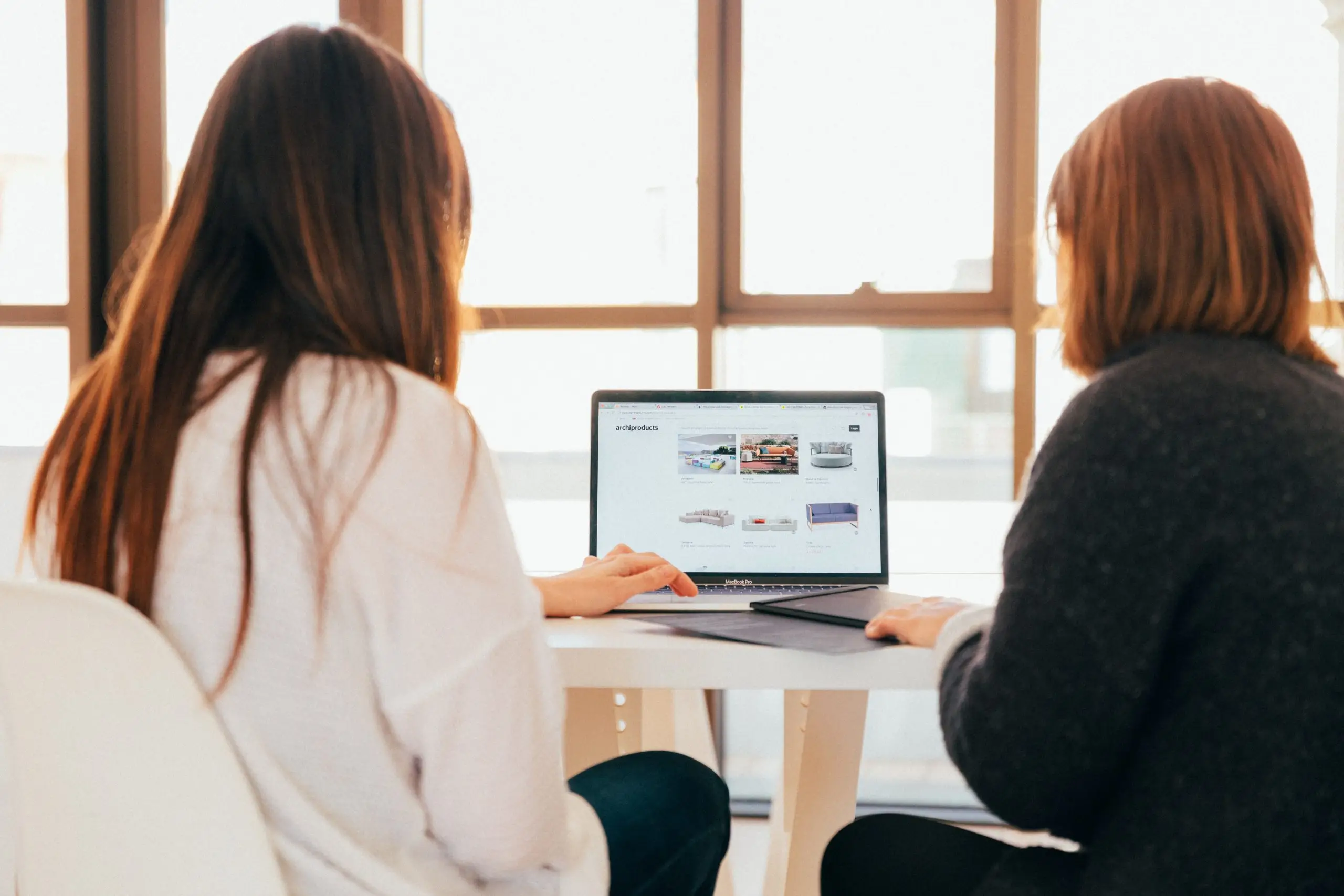 two women working at a laptop