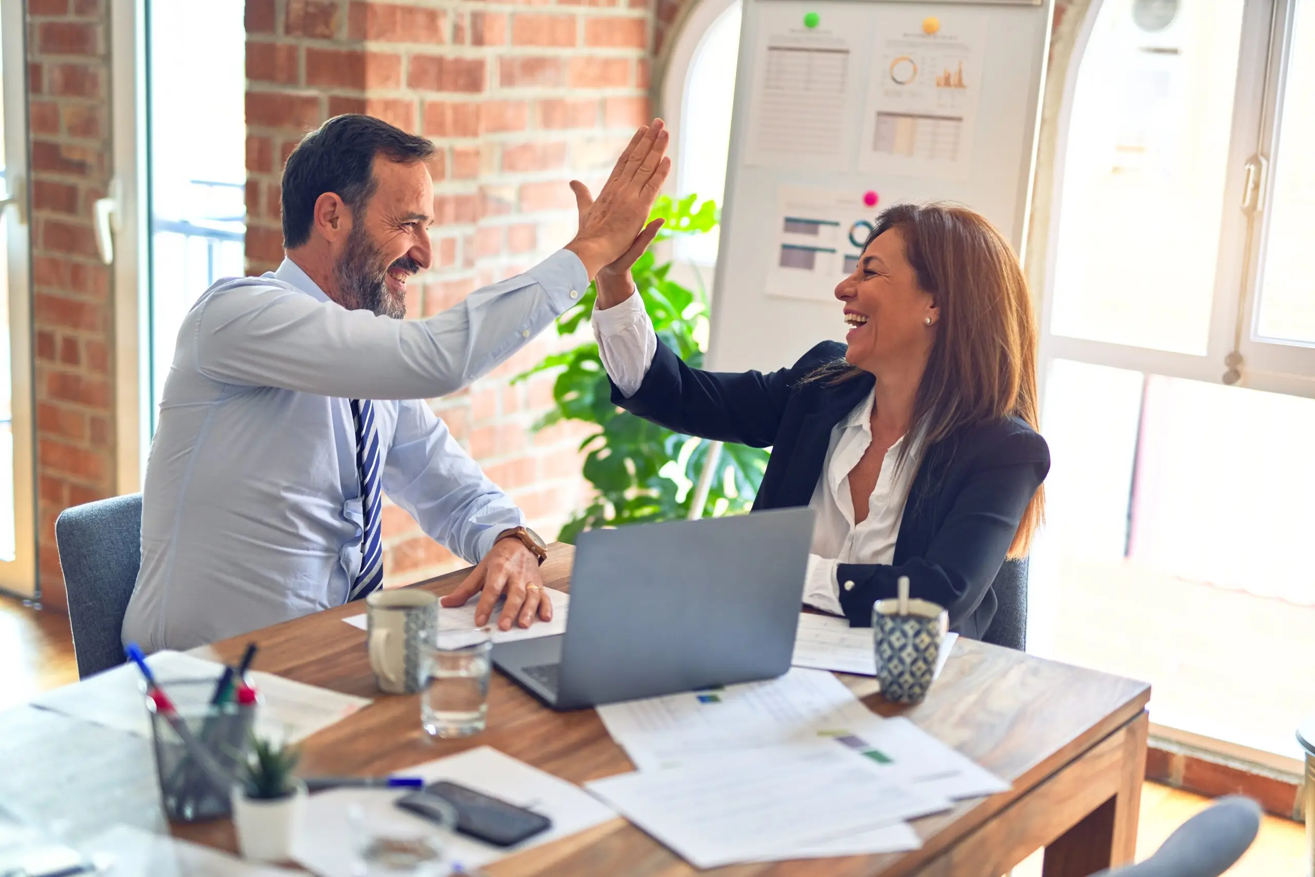male and female professional high fiving
