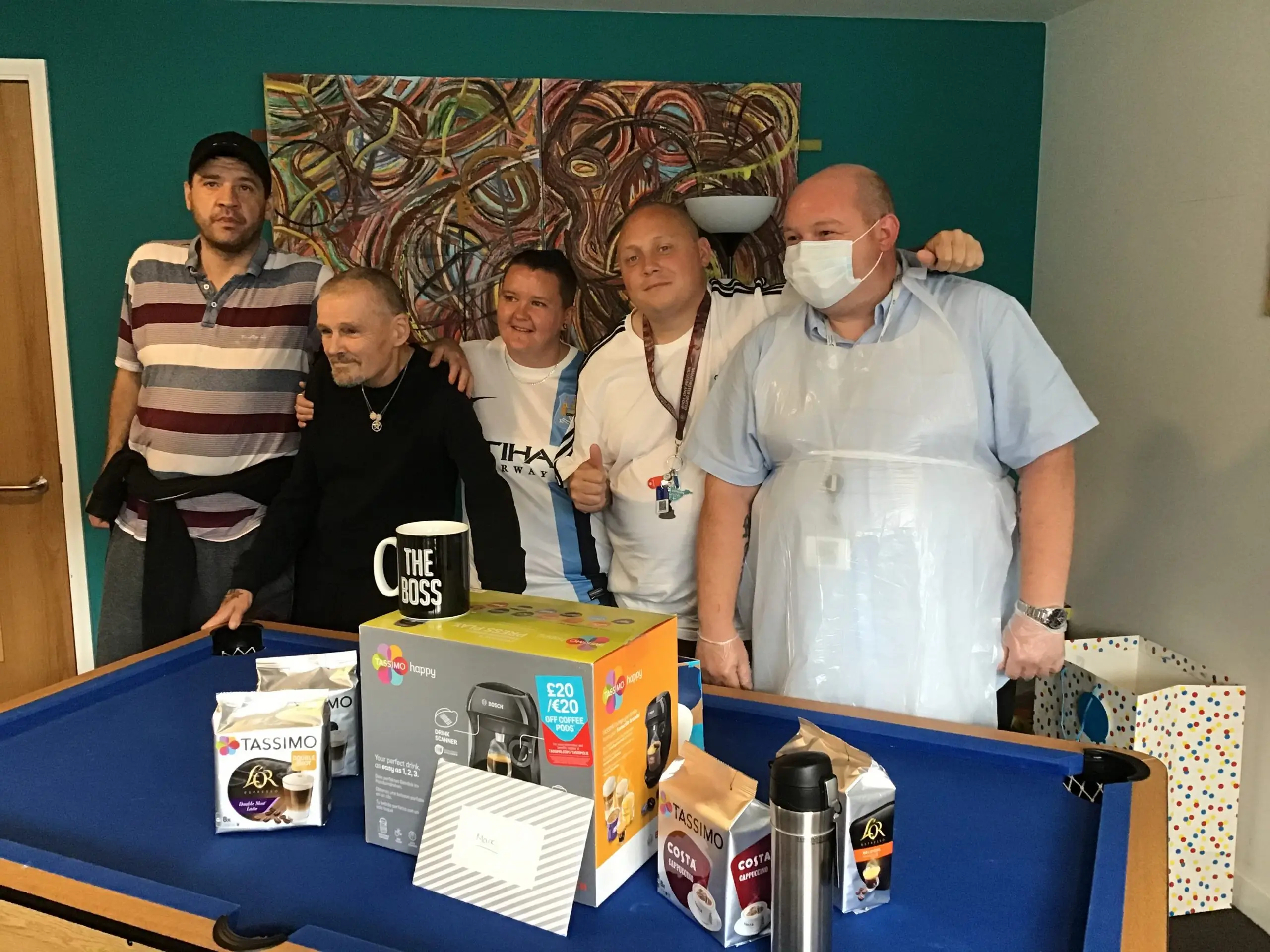 residents and team member posing with coffee machine