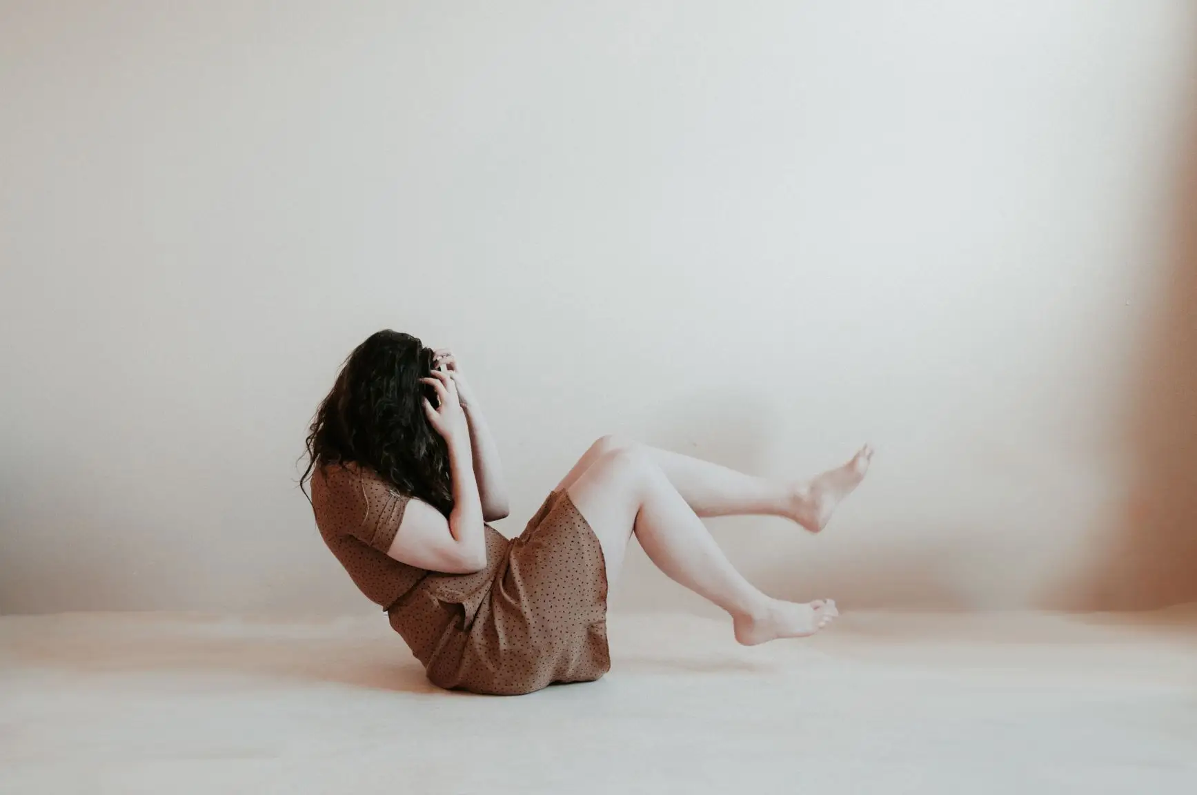 Woman on the floor with head in hands