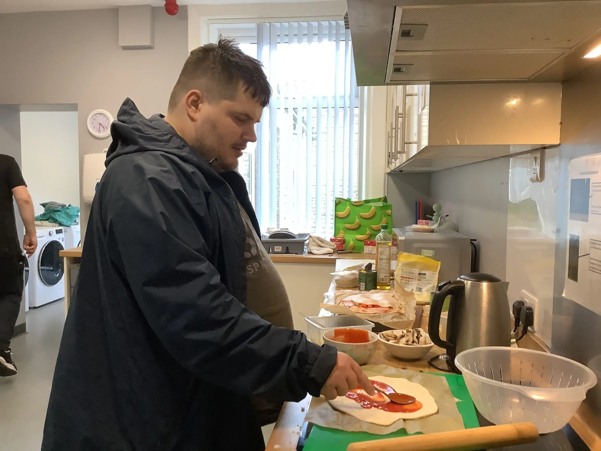 male resident making pizza