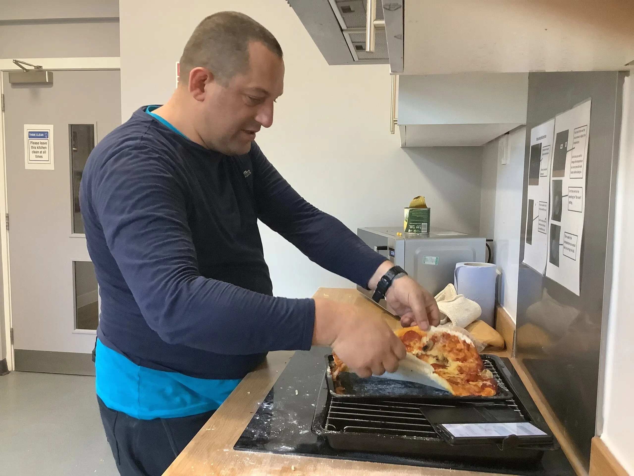 male resident making pizza