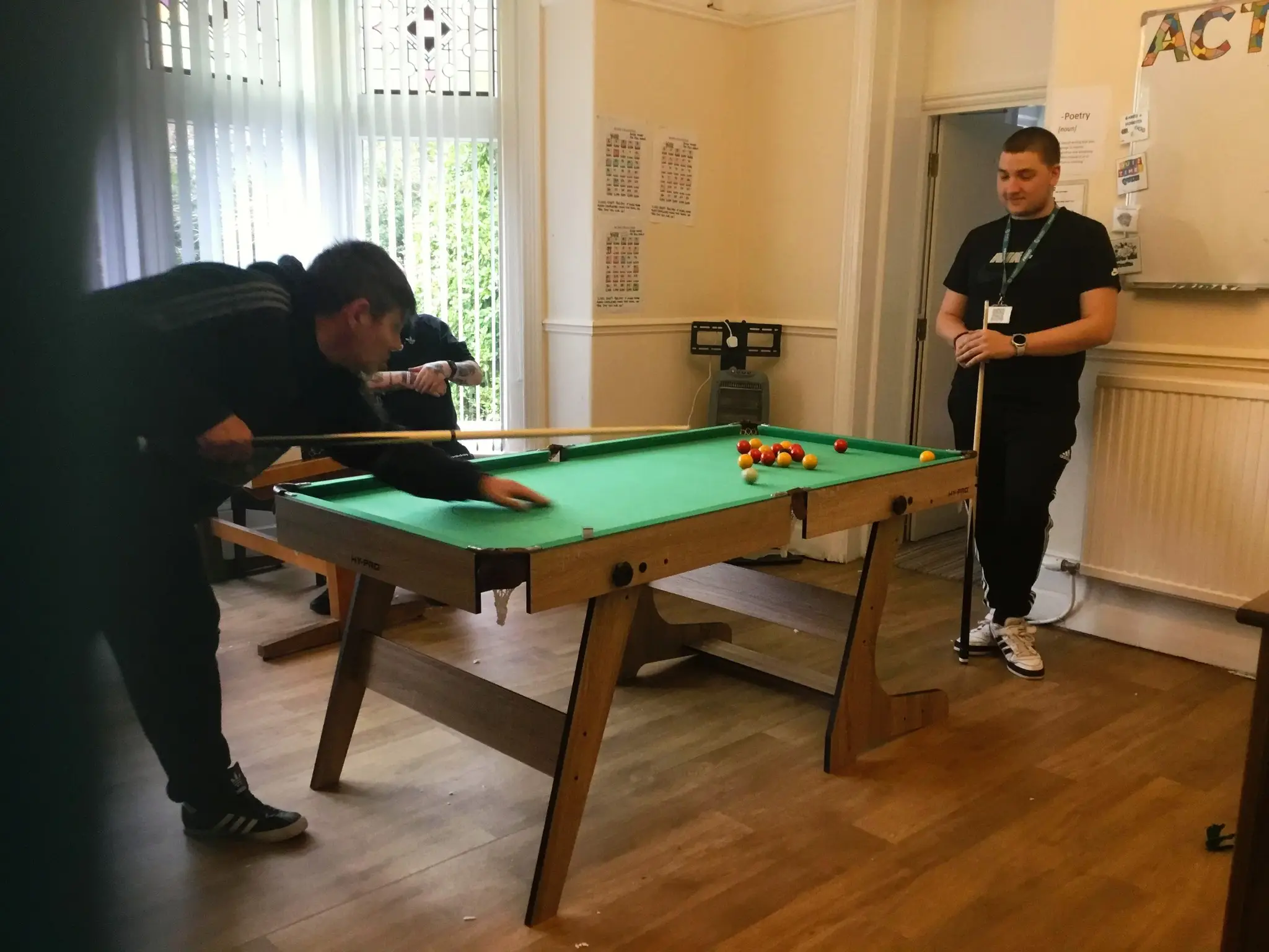 Two residents playing pool