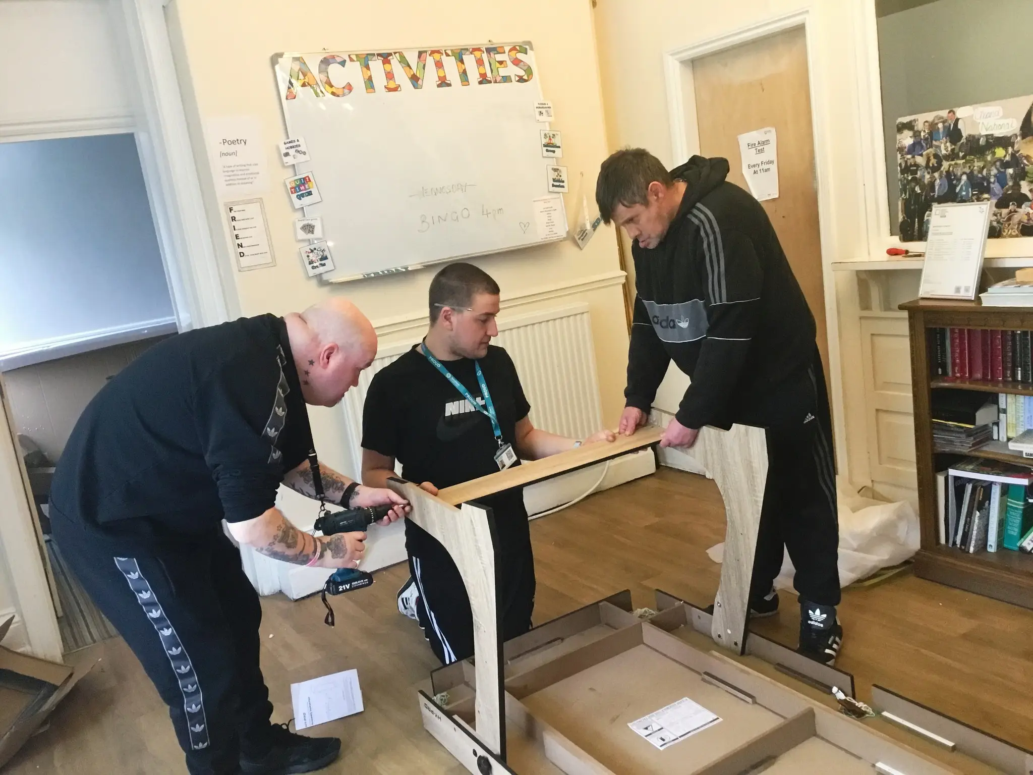 Residents and team members building pool table