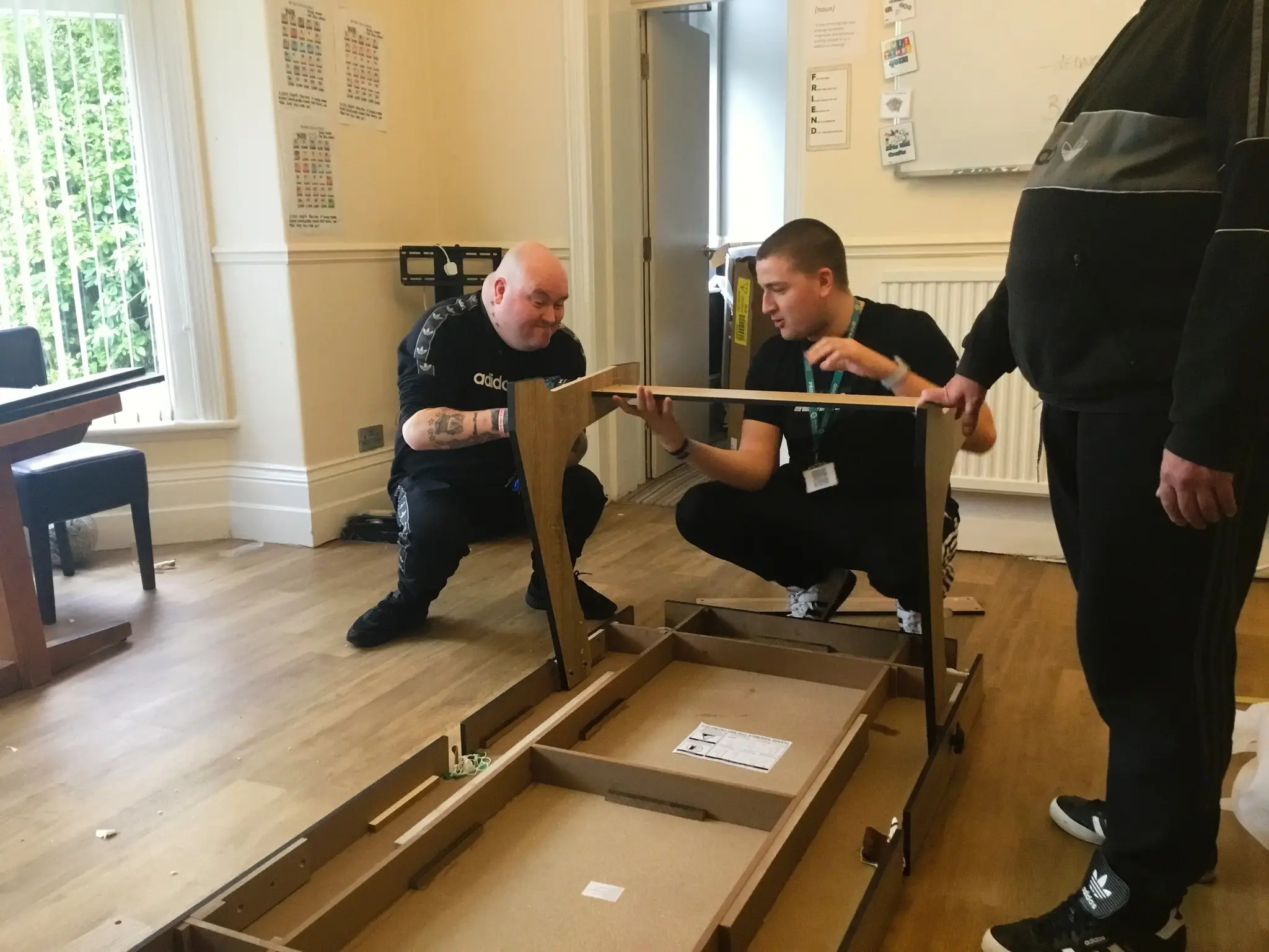 Resident and team member constructing pool table