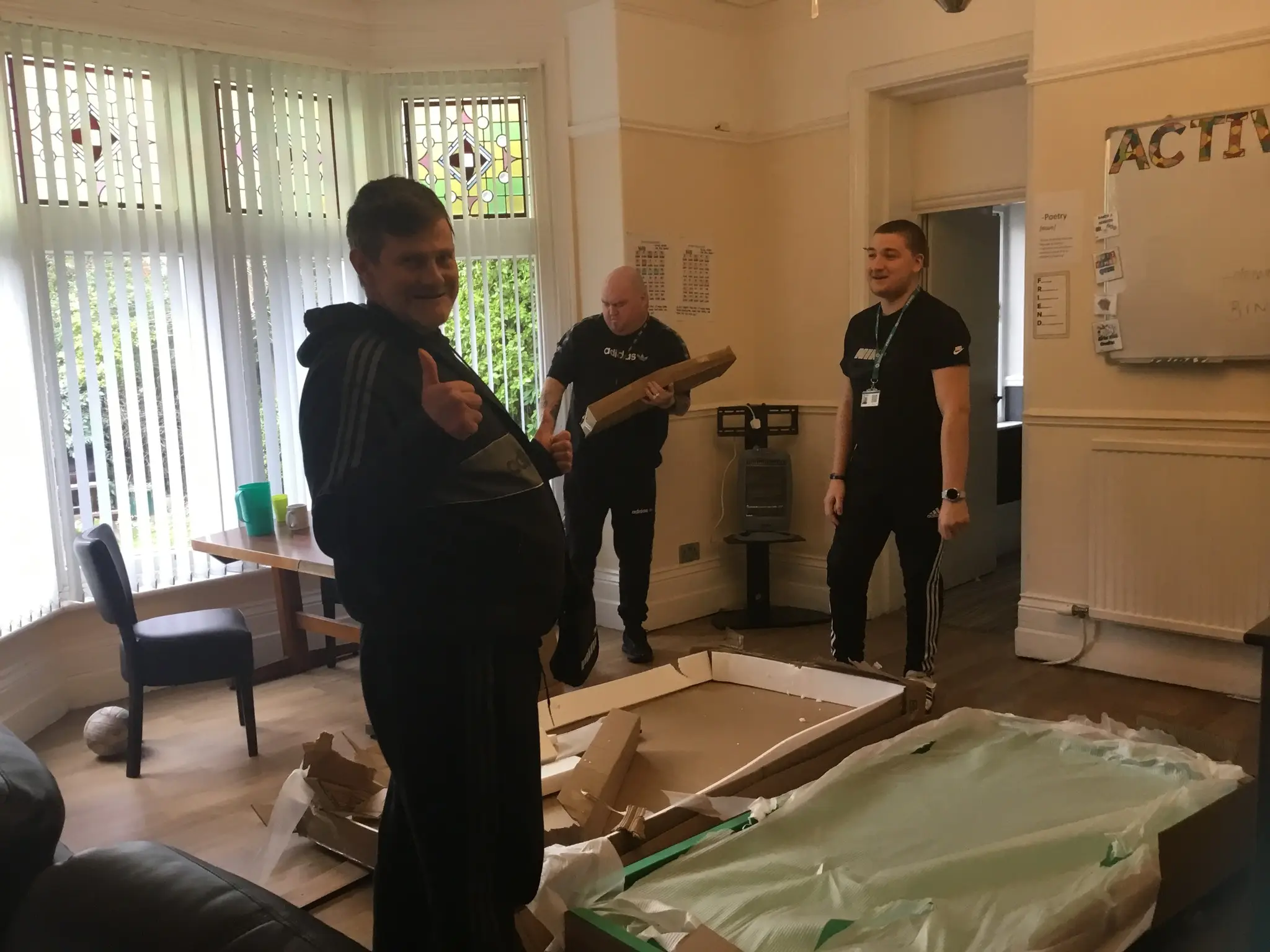 Resident and team member unpacking pool table